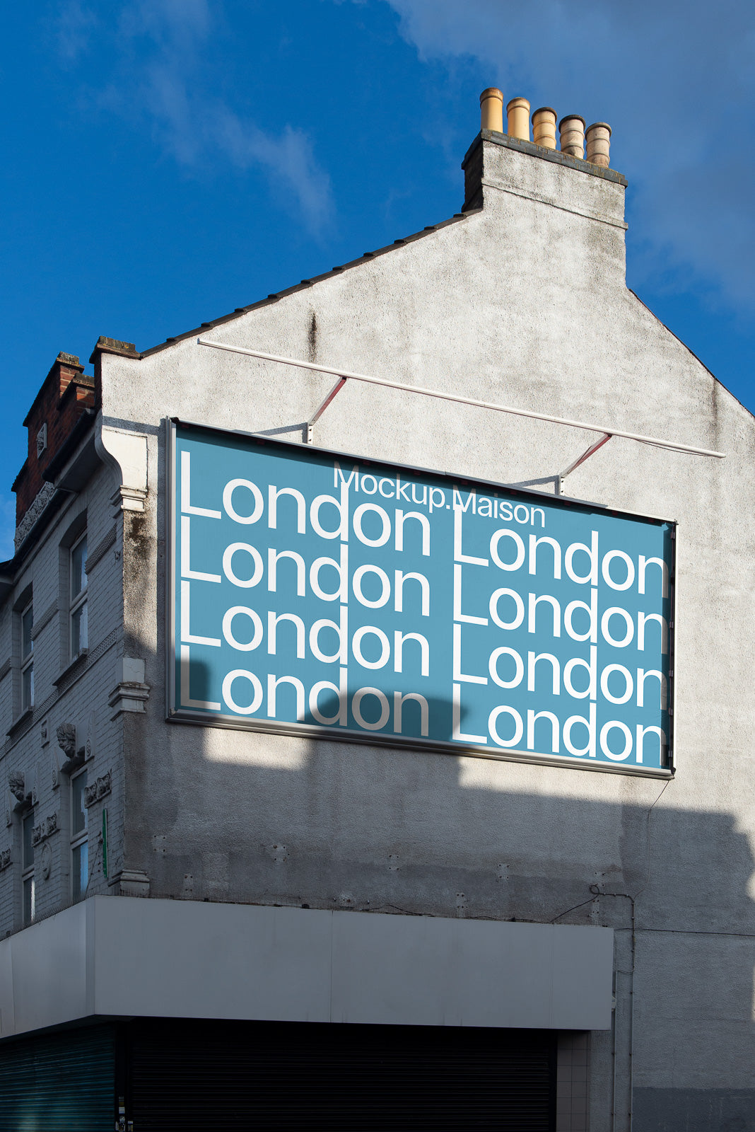 PSD mockup of a large billboard on the side of a building featuring the word "London" in bold white letters on a blue background under a clear sky.