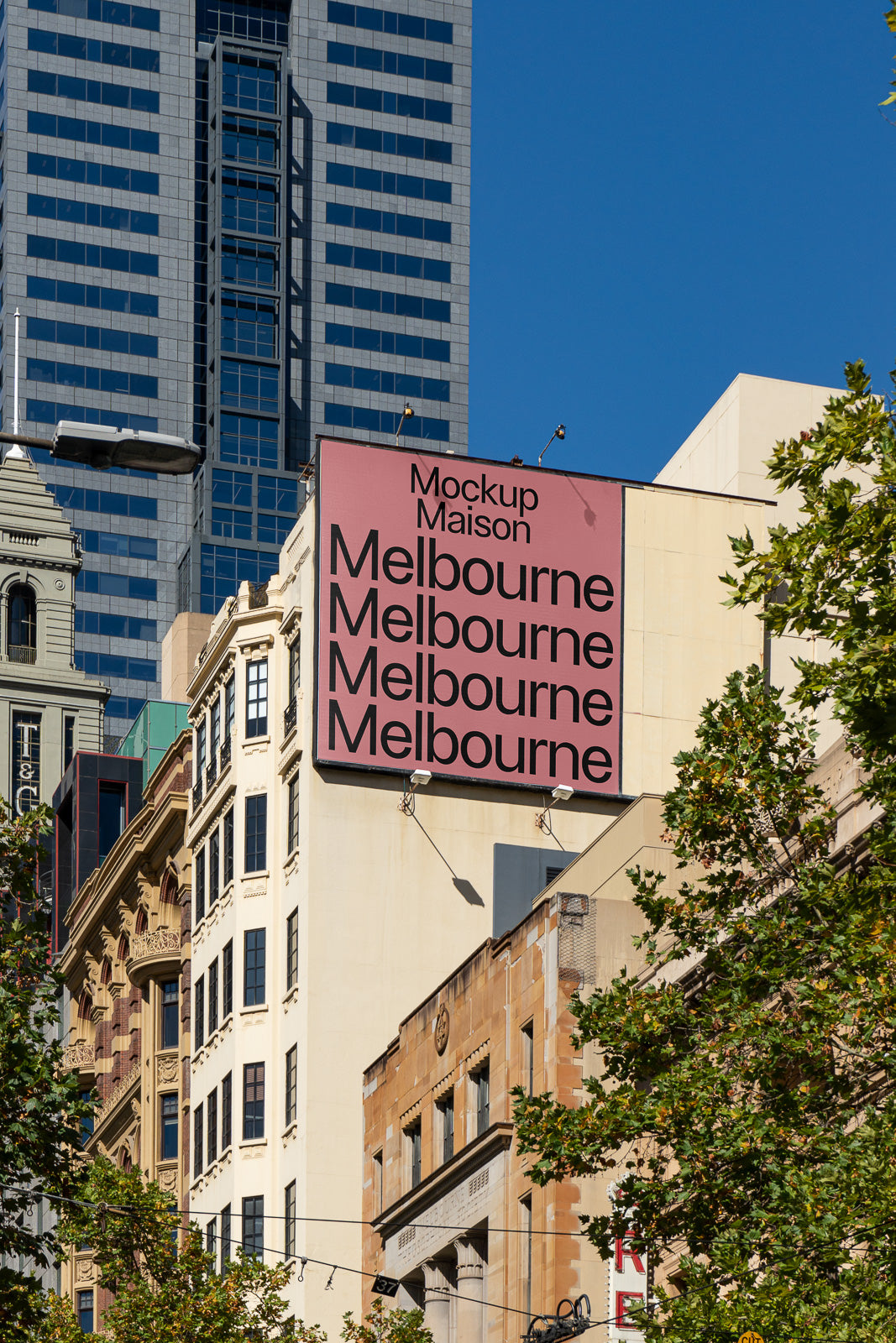 PSD mockup of an urban billboard on a building facade with the word "Melbourne" repeated, set against a cityscape background with clear blue skies.