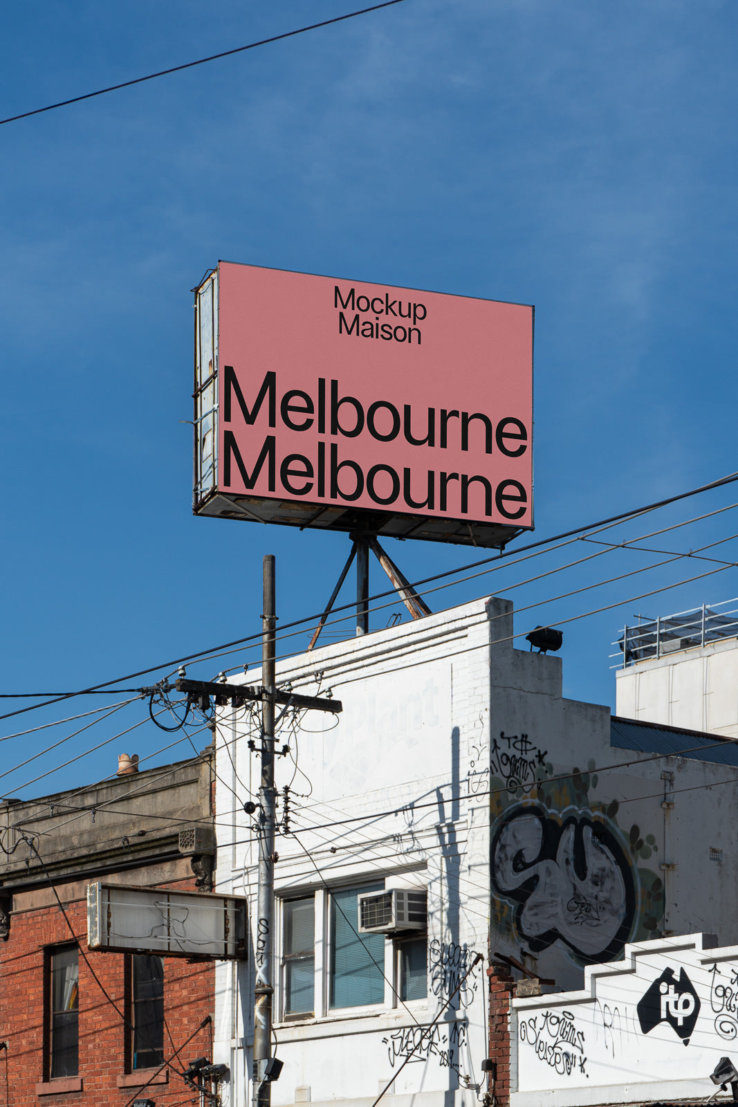 PSD mockup of a large billboard in an urban setting, showcasing "Melbourne" in bold black letters against a pink background, with clear blue sky overhead.