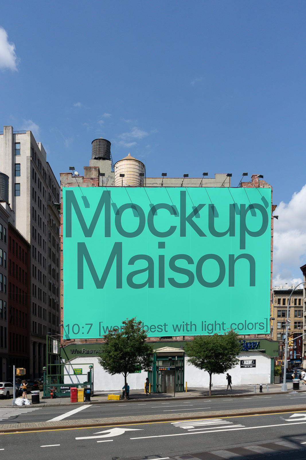PSD mockup of a large green billboard with the text "Mockup Maison" displayed on the side of an urban building under a clear blue sky.