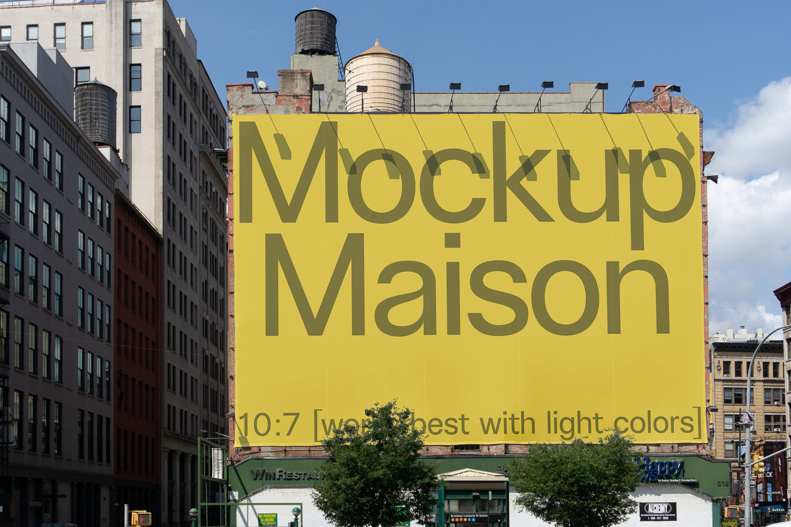 PSD mockup of a large yellow billboard on a city building, displaying the words "Mockup Maison" and additional text indicating light color suitability.