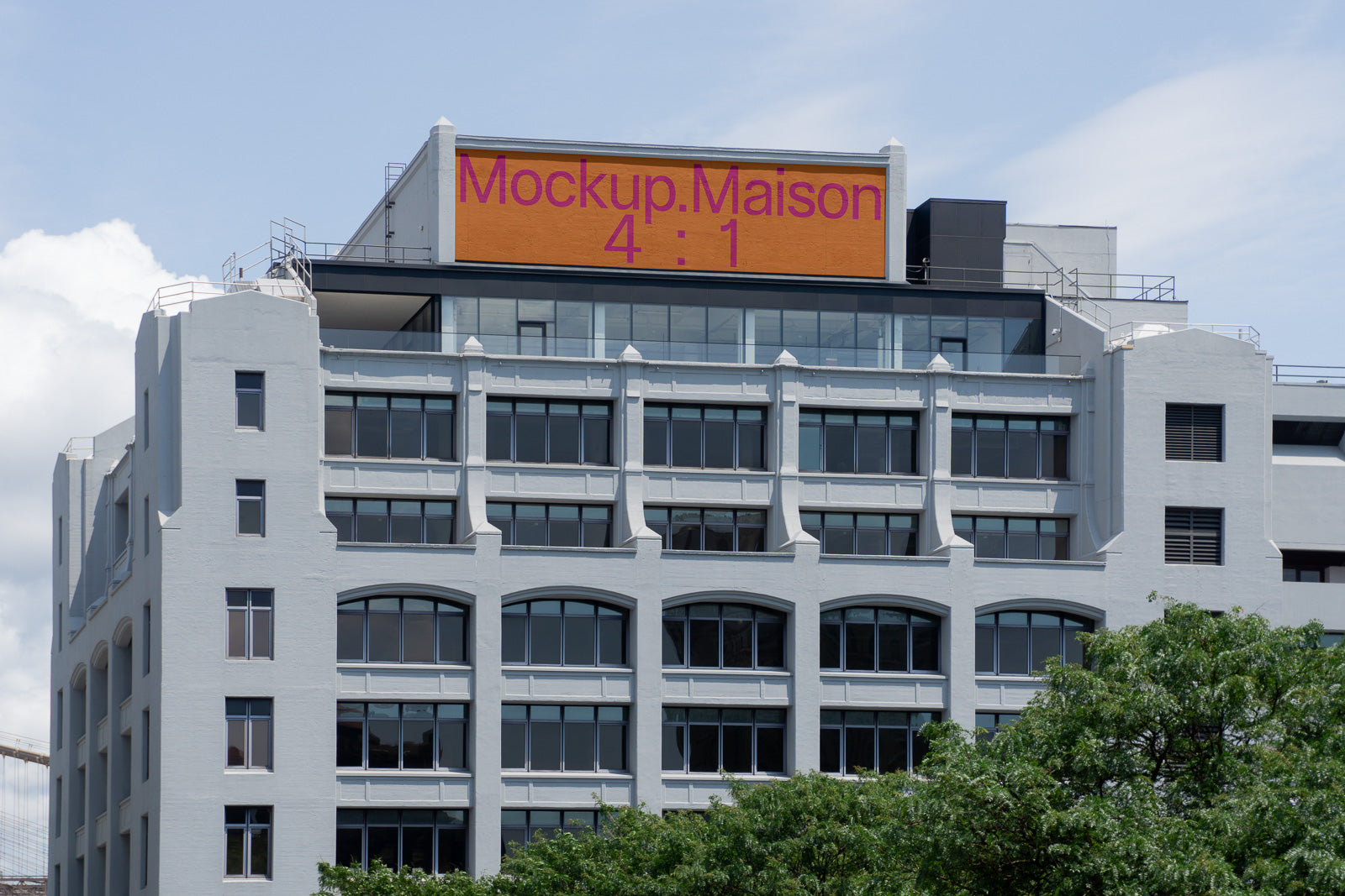 PSD mockup of a large digital billboard atop a modern gray building, displaying the text "Mockup Maison 4:1" against an orange background.