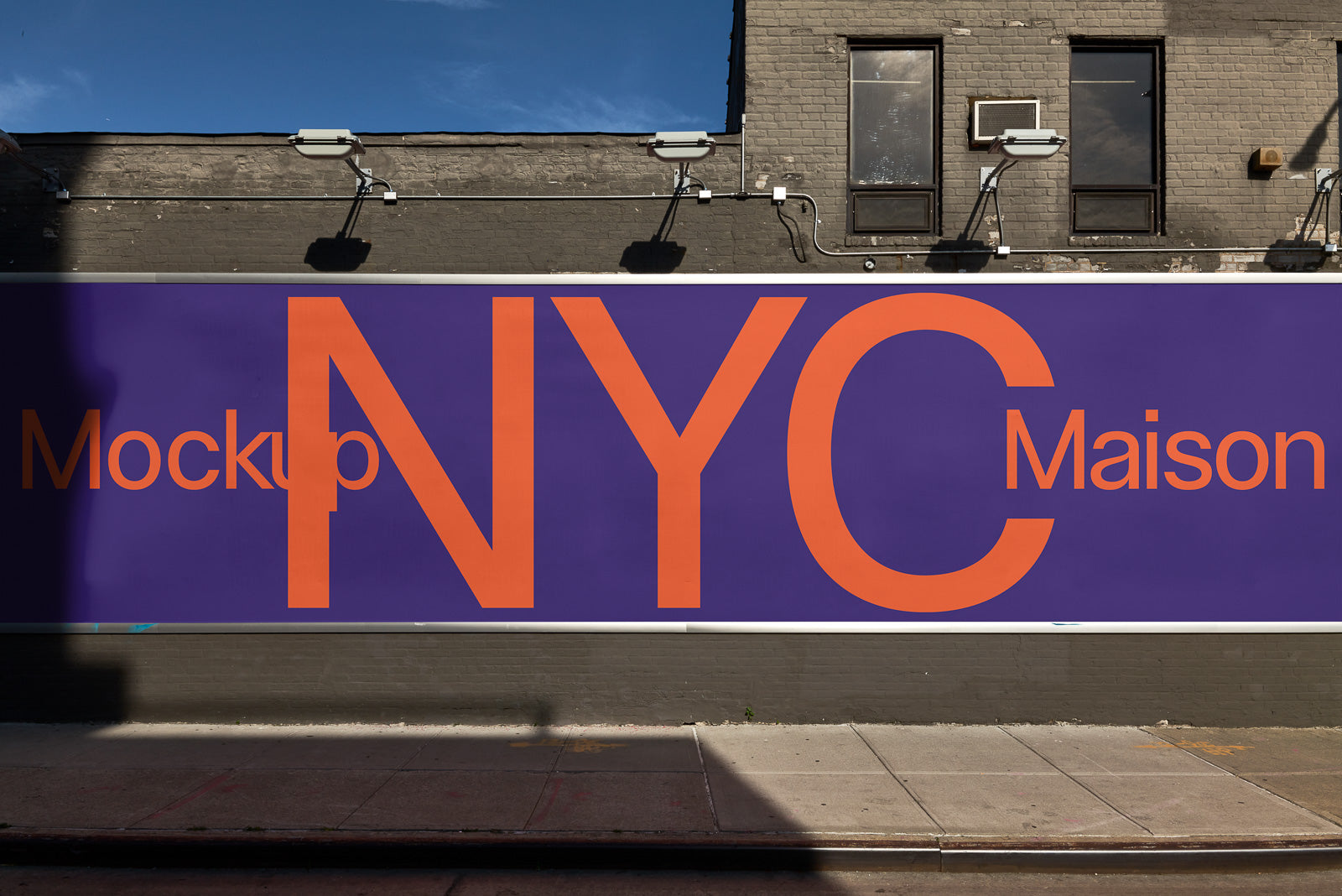 PSD mockup of a large outdoor billboard featuring "NYC Maison" in bold orange letters against a purple background, mounted on a brick wall.