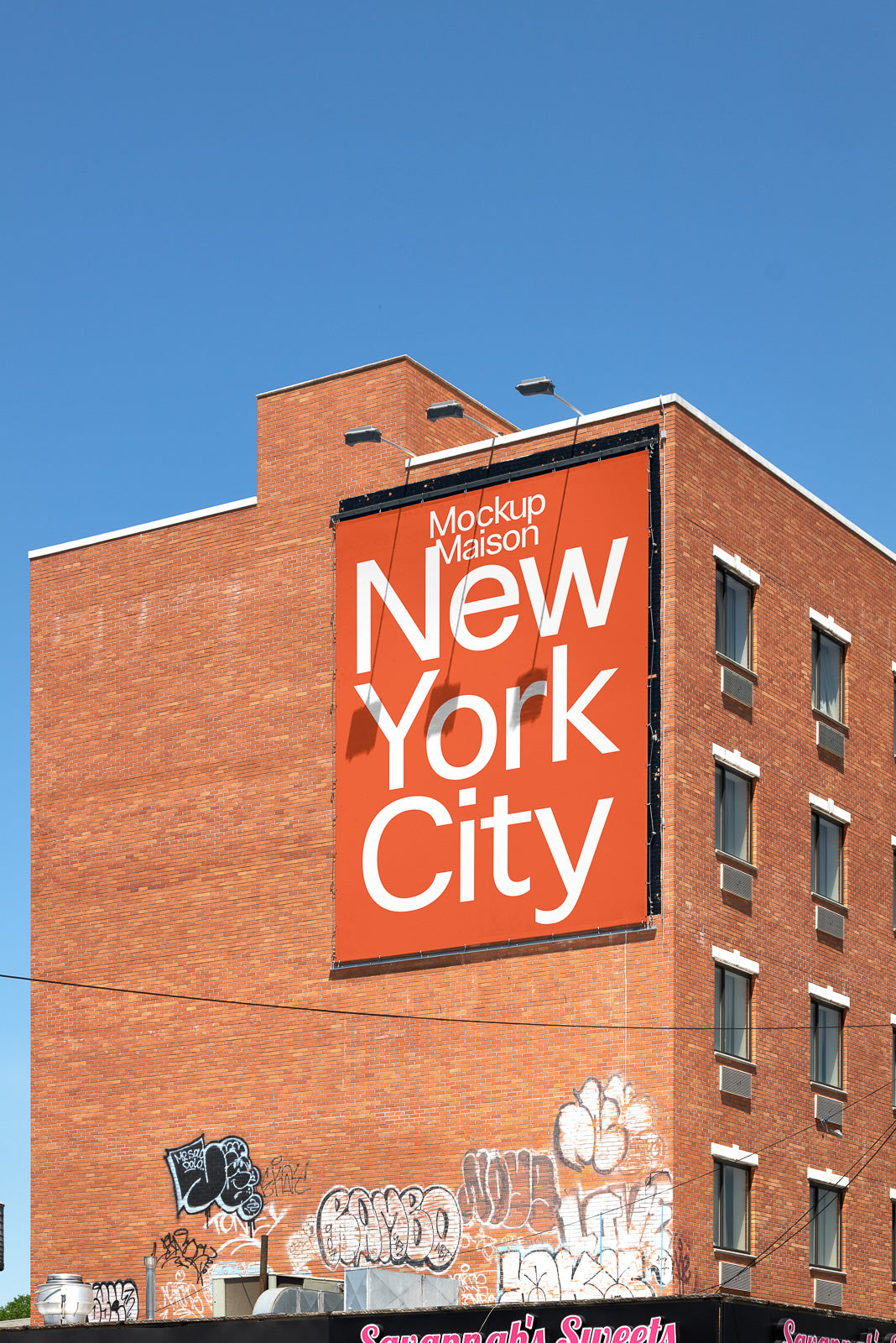 PSD mockup of a large orange billboard on a brick building with bold white text reading "New York City" and graffiti on the lower wall.