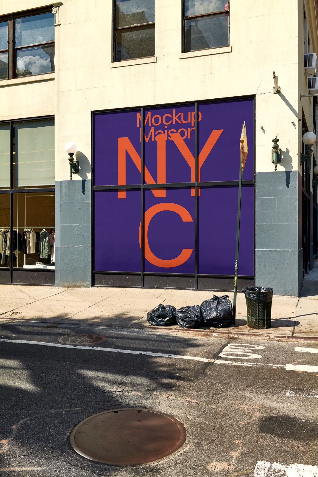 PSD mockup of a building facade featuring large purple advertisement windows with orange text that reads "Mockup Maison NYC," next to street and trash bags.