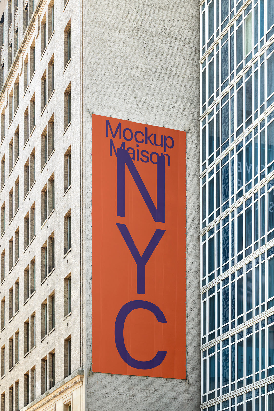 PSD mockup of a large vertical orange banner with "Mockup Maison NYC" in purple letters on the side of a building, adjacent to windows.