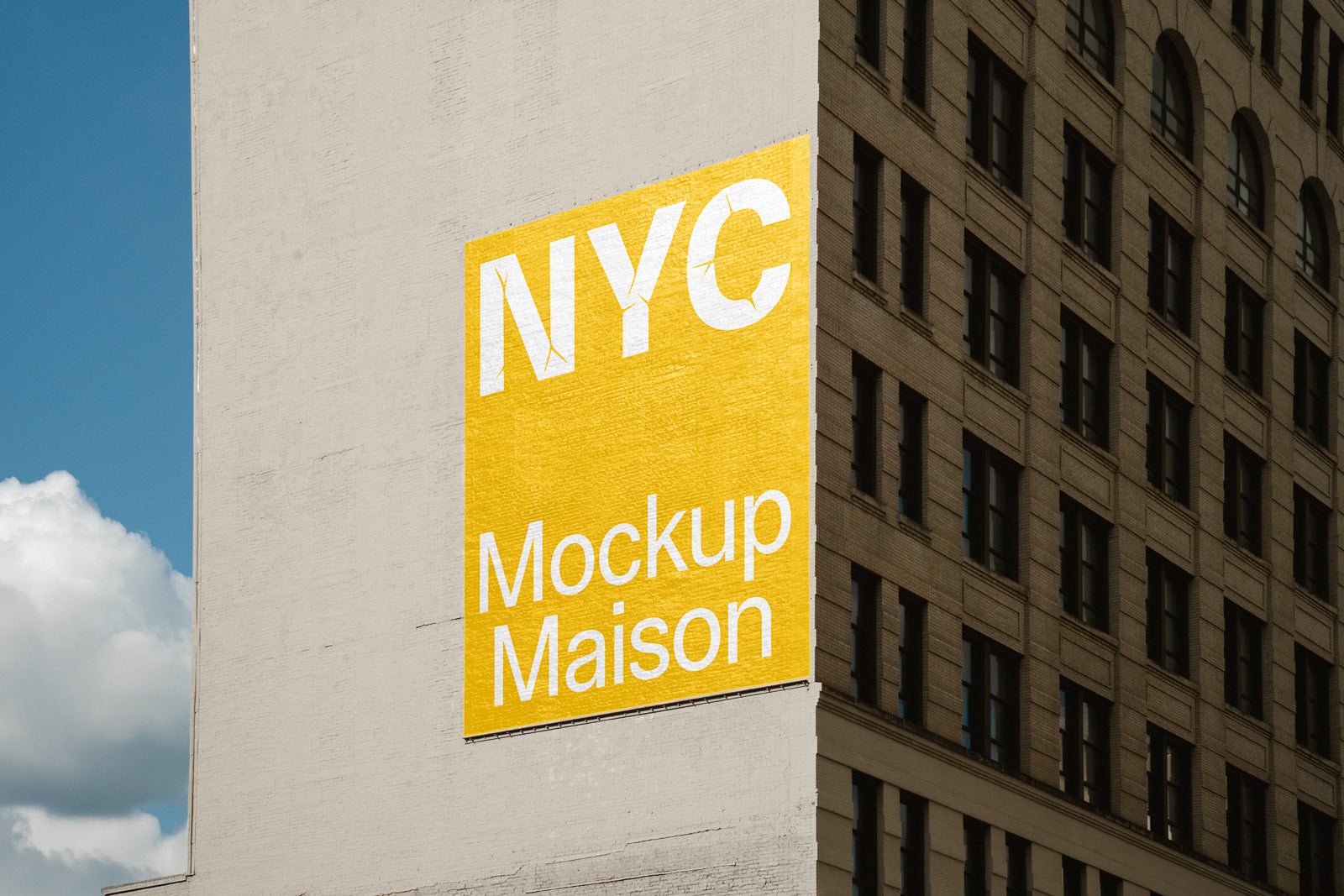 PSD mockup of a large yellow billboard on an urban building wall, displaying the text "NYC Mockup Maison" with a clear sky background.