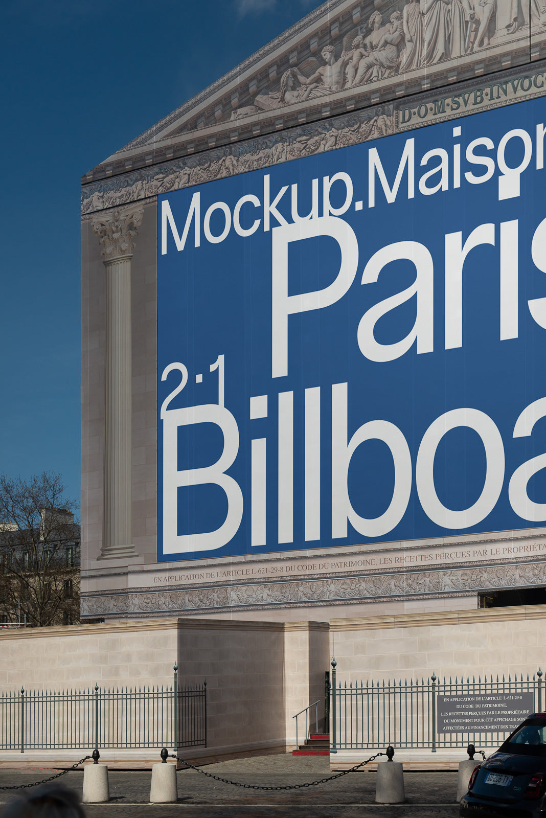 PSD mockup of a large billboard displayed on the side of a classical building under a clear blue sky.
