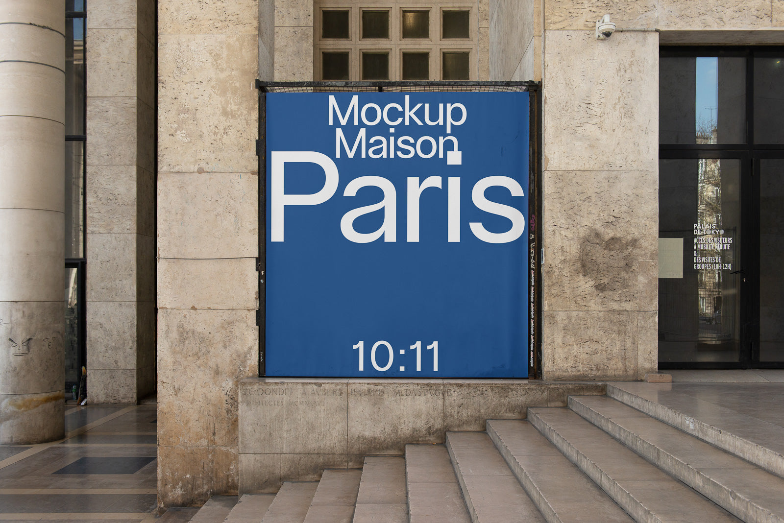 PSD mockup of a large blue poster with white text reading "Mockup Maison Paris 10:11," displayed on a stone wall next to a staircase and building entrance.
