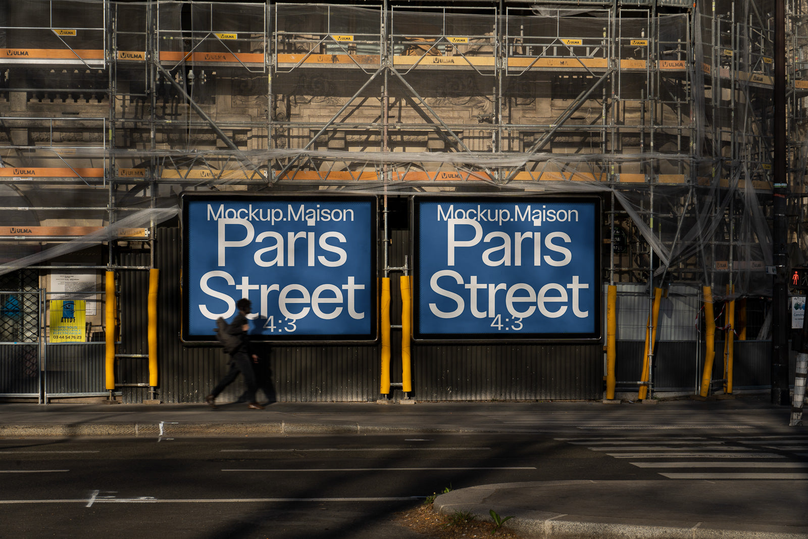 PSD mockup of two large blue billboard displays reading "Paris Street 4:3" on a construction site, with a person walking past in the foreground.