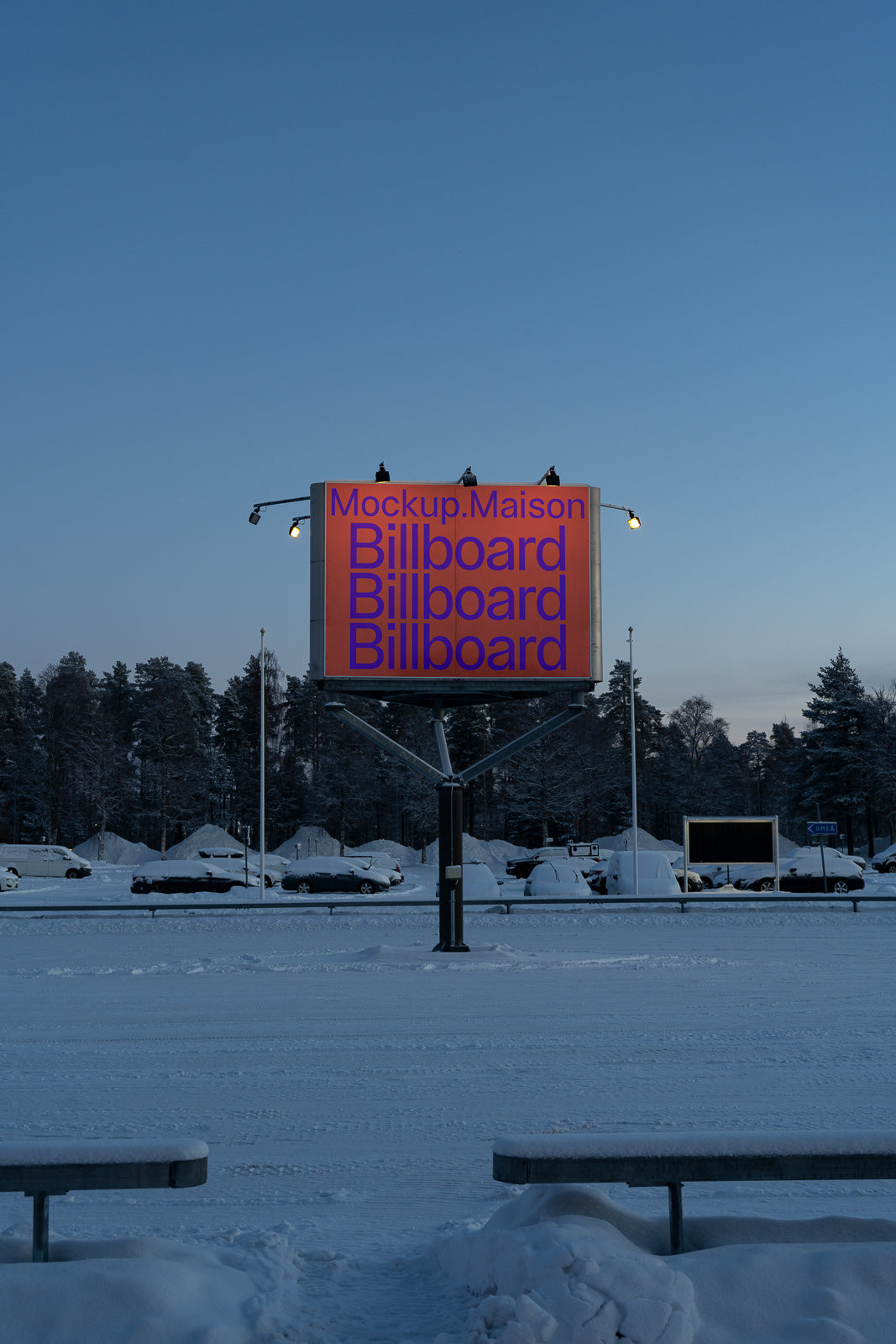 PSD mockup of a large illuminated billboard in a snowy parking lot, surrounded by parked cars and trees under a clear sky.