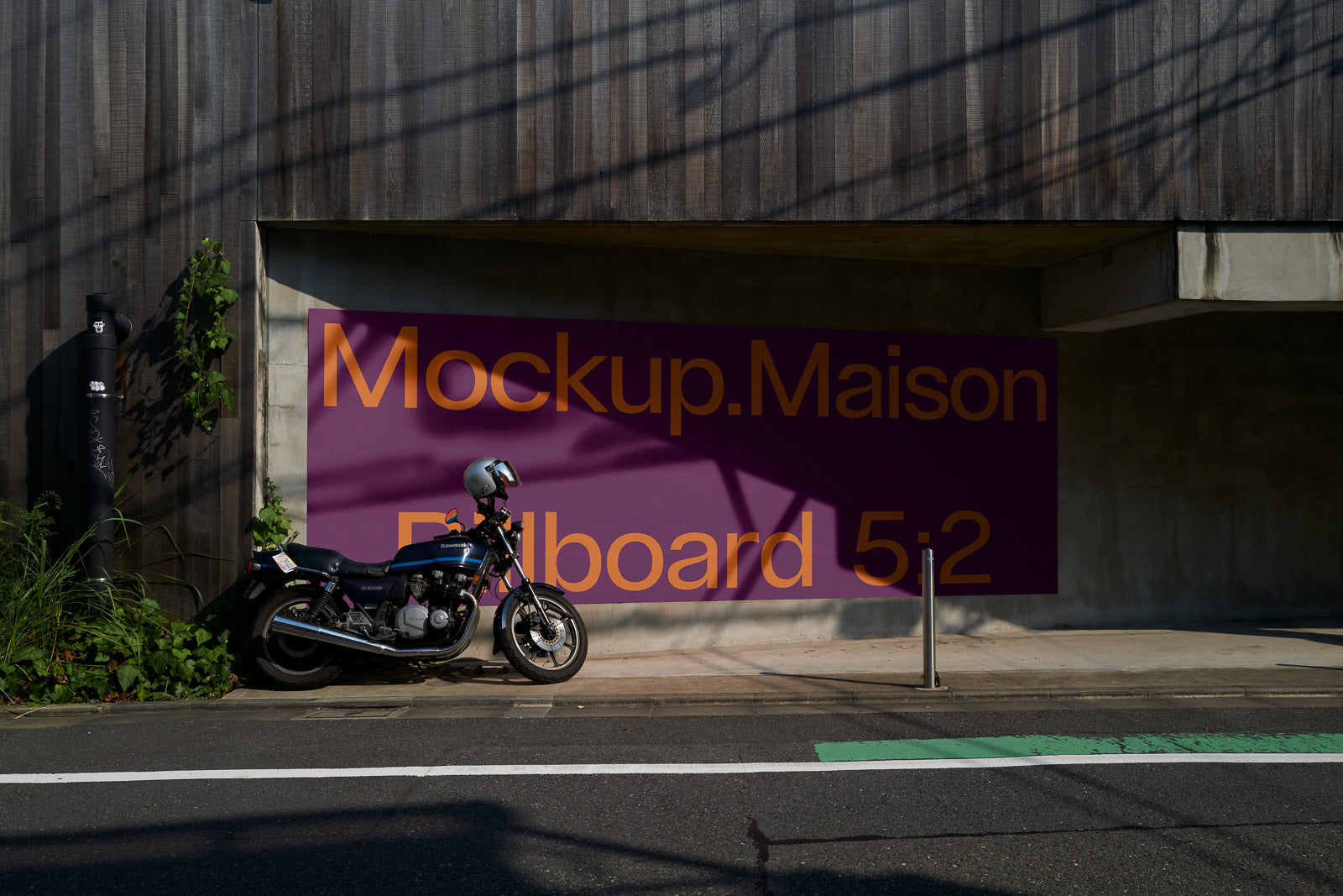 PSD mockup of an urban scene featuring a motorcycle parked beside a large billboard displaying the text "Mockup.Maison Billboard 5:2" against a purple background.