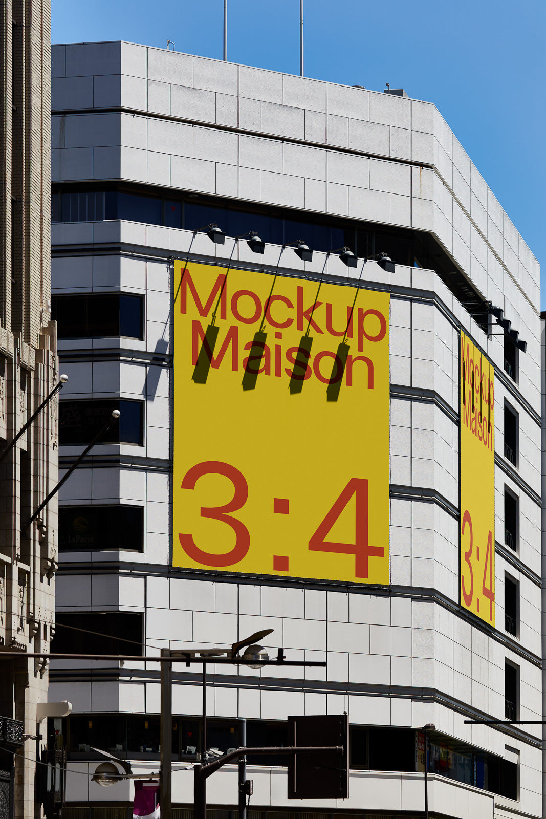 PSD mockup of a large rectangular yellow banner with red text reading "Mockup Maison 3:4" displayed on a modern white building facade.