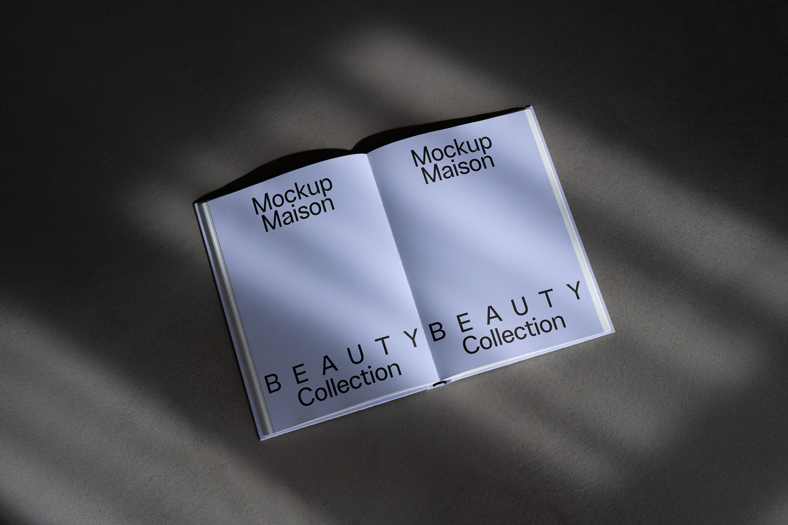 PSD mockup of an open book titled "Mockup Maison Beauty Collection" on both pages, with soft shadows on a textured surface.