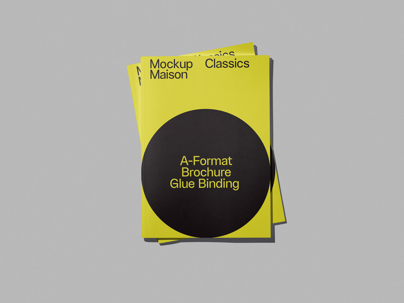 PSD mockup of two yellow brochures with "A-Format Brochure Glue Binding" text in a black circle, placed against a gray background.