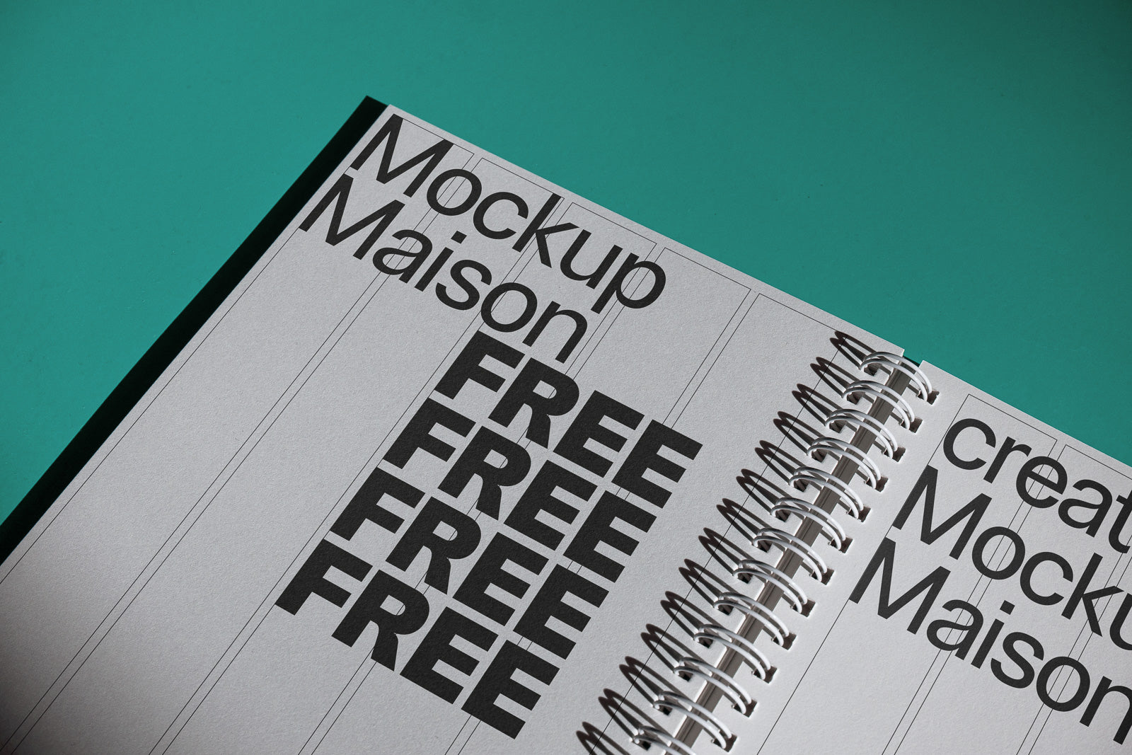 PSD mockup of an open spiral-bound notebook with bold black text "Mockup Maison" and "FREE" on a teal background.