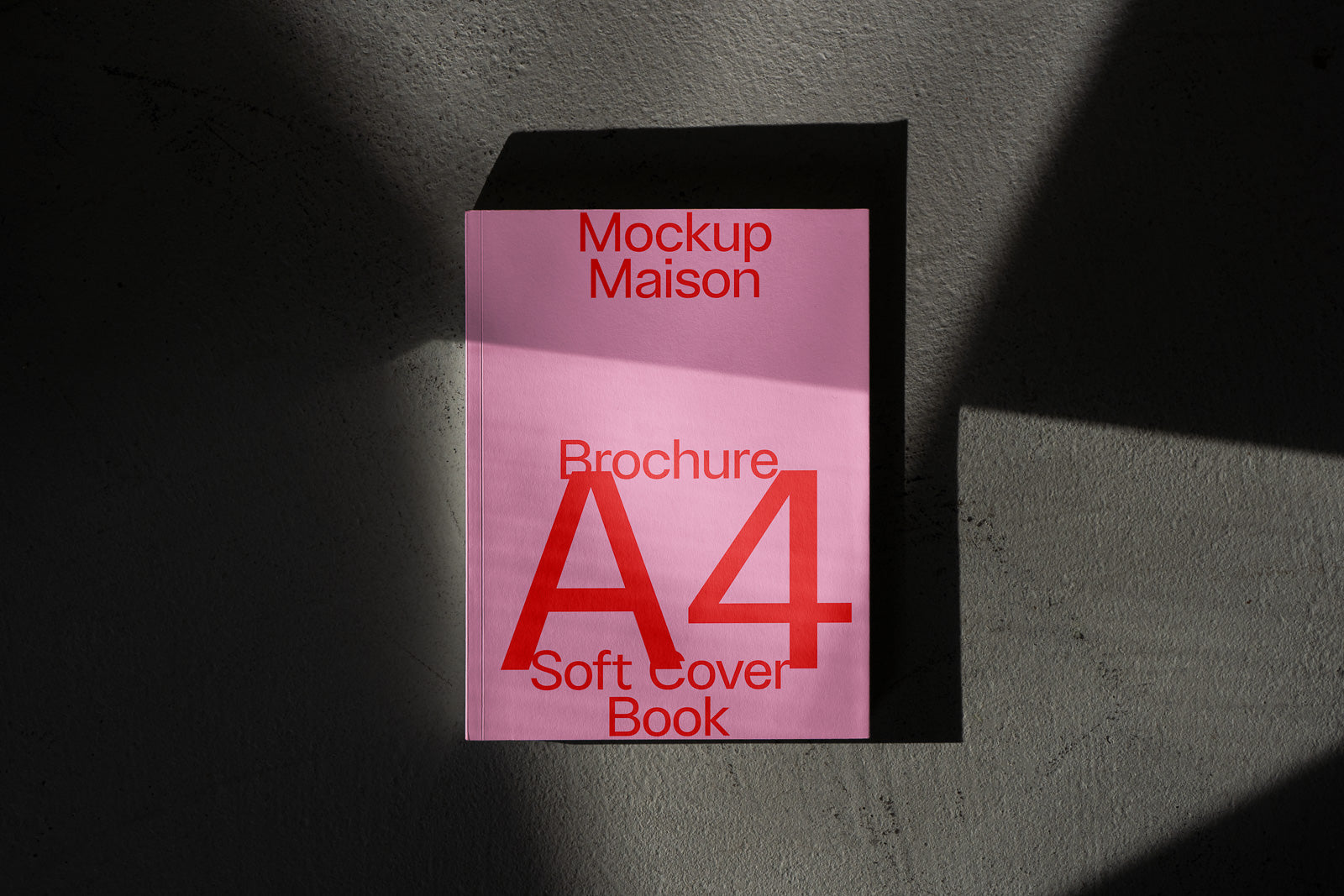 PSD mockup of a pink A4 brochure design titled "Mockup Maison" with red text, casting a shadow on a textured surface.