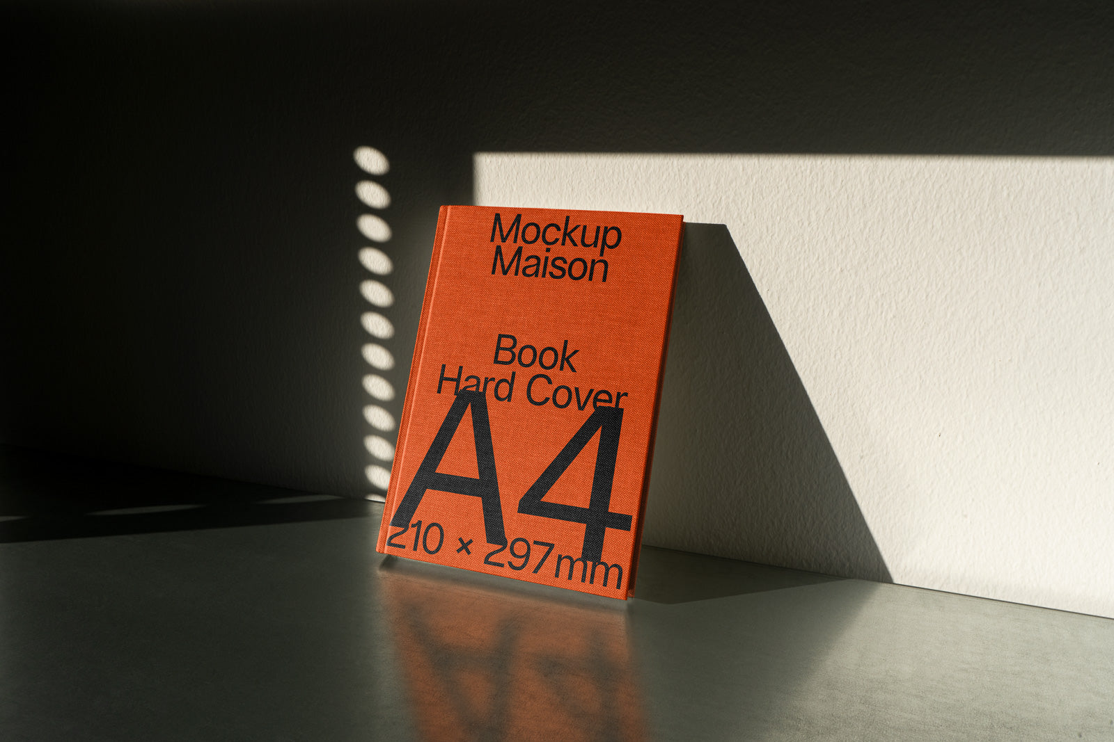 PSD mockup of an A4 hardcover book with an orange cover leaning against a wall, displaying shadow patterns on the surface.