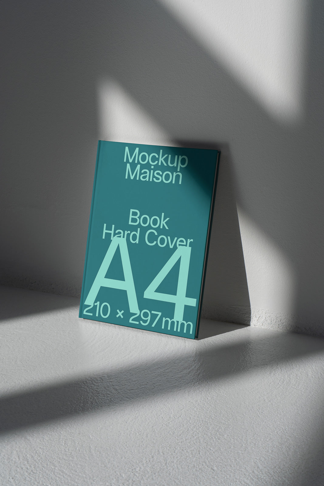 PSD mockup of an A4 hardcover book titled "Mockup Maison" leaning against a wall, with the dimensions 210 x 297 mm.