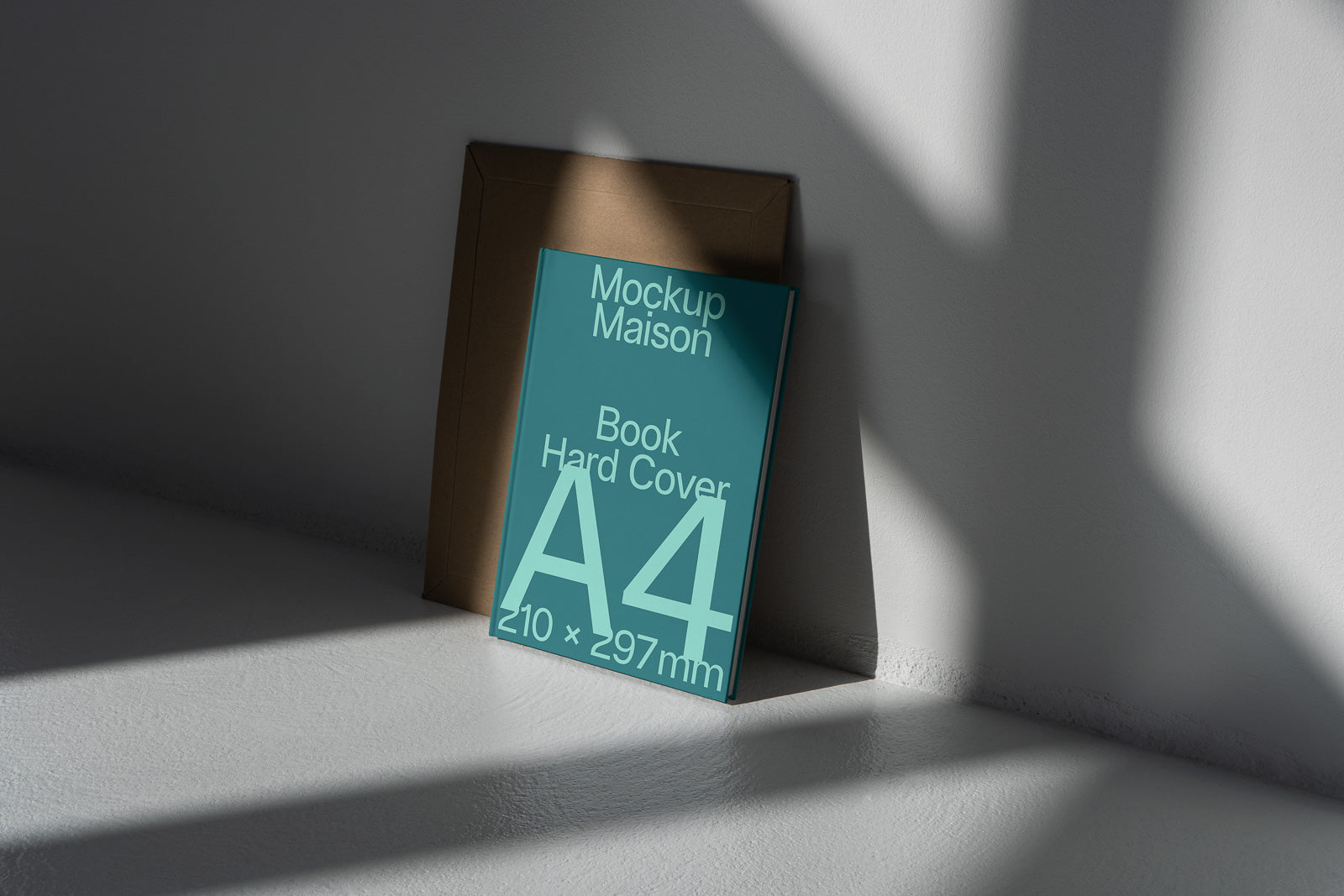 PSD mockup of an A4 hardcover book leaning against a wall, with natural light casting shadows on a white surface.