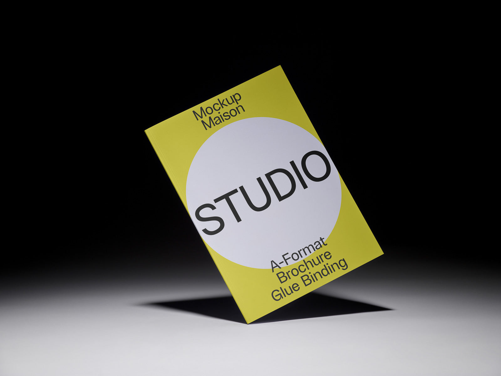 PSD mockup of a yellow A-Format brochure with glue binding, featuring the word "STUDIO" in large letters and shadowed against a dark background.