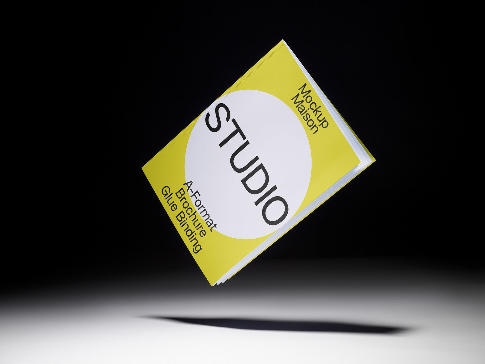 PSD mockup of a yellow and white brochure titled "Studio" in mid-air against a dark background, displaying A-format and glue binding details.