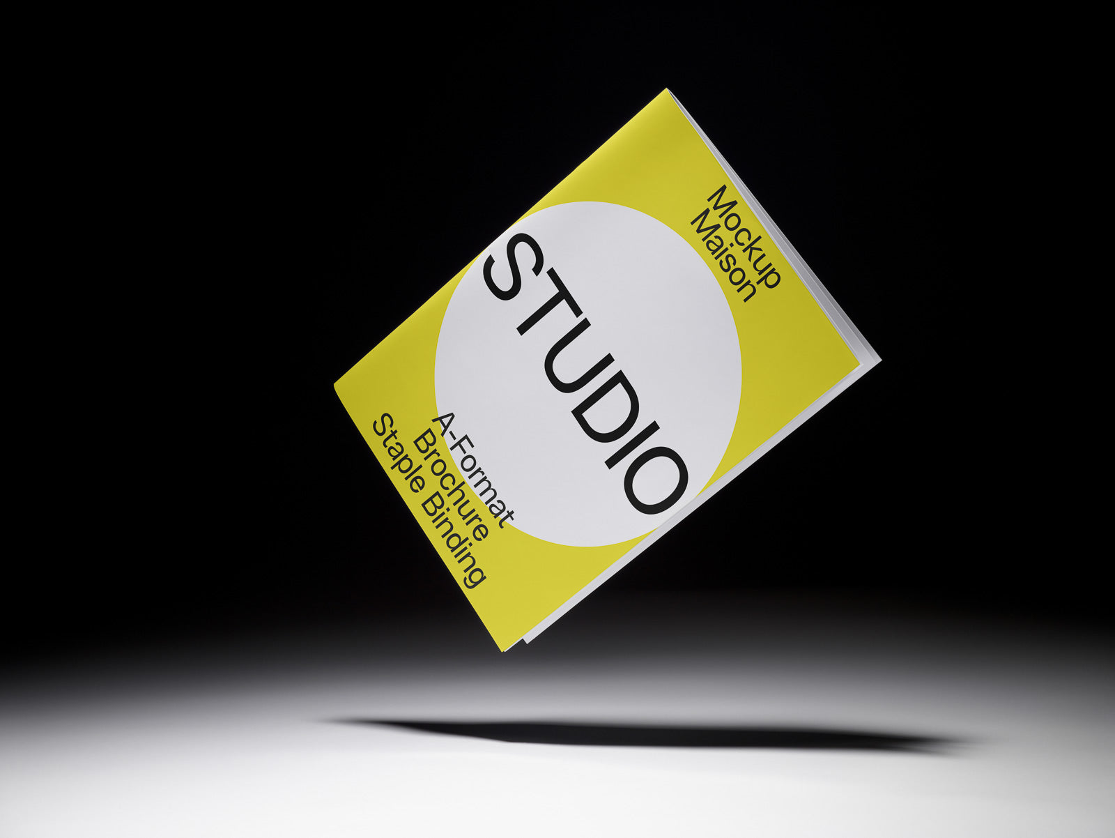 PSD mockup of a floating A-format brochure with a yellow and white cover design labeled "Studio," featuring staple binding against a dark background.