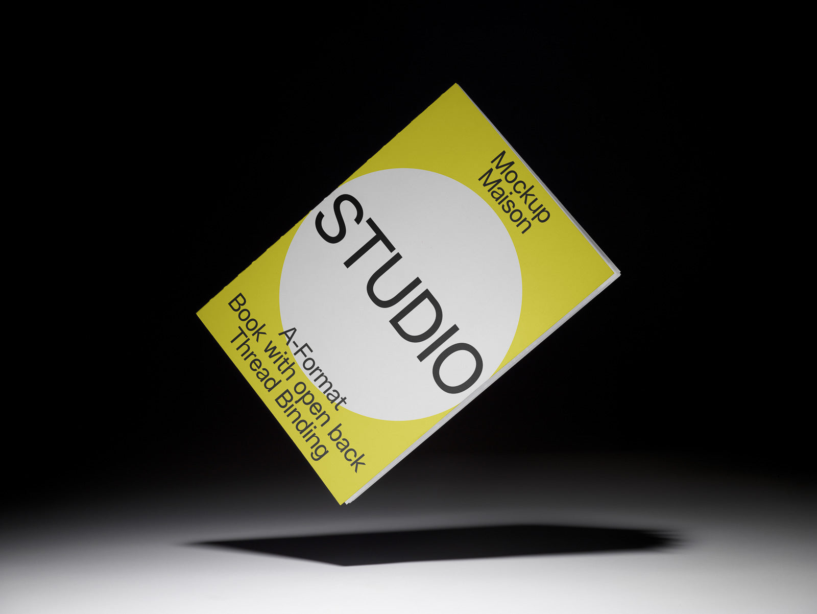 PSD mockup of an A-format book with yellow and white cover floating against a dark background, featuring the title "Studio" and open back thread binding.