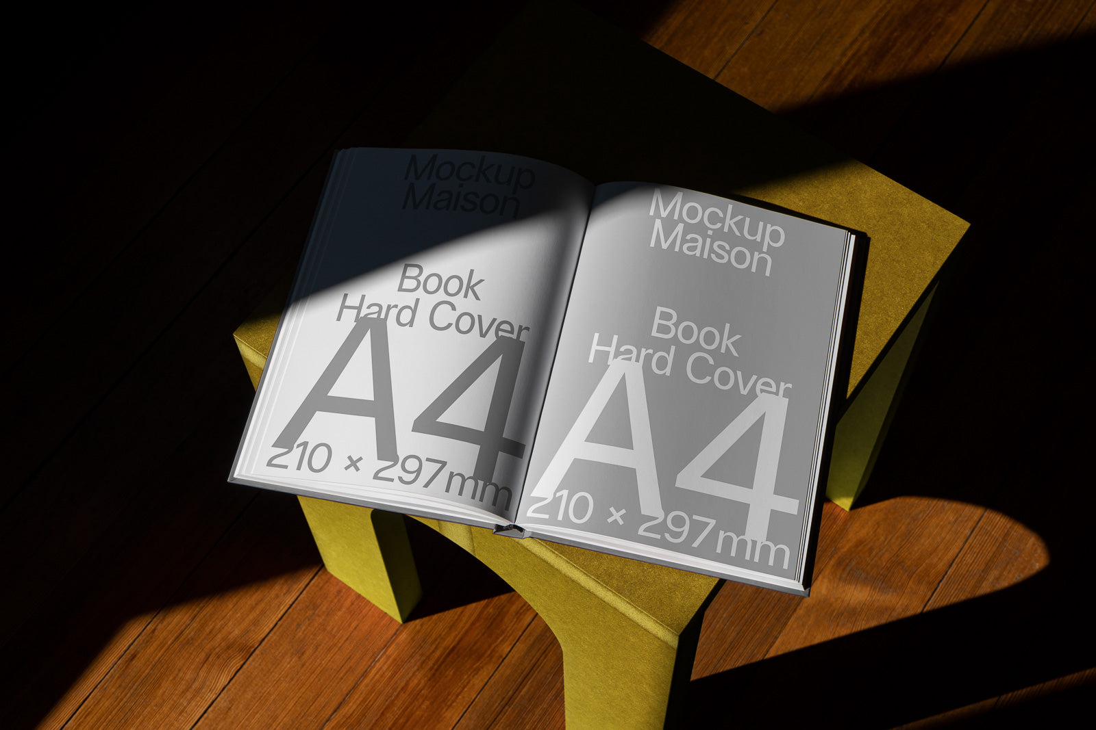 PSD mockup of an open A4 hard cover book on a small green stool, featuring large text and dimensions illuminated by sunlight on a wooden floor.