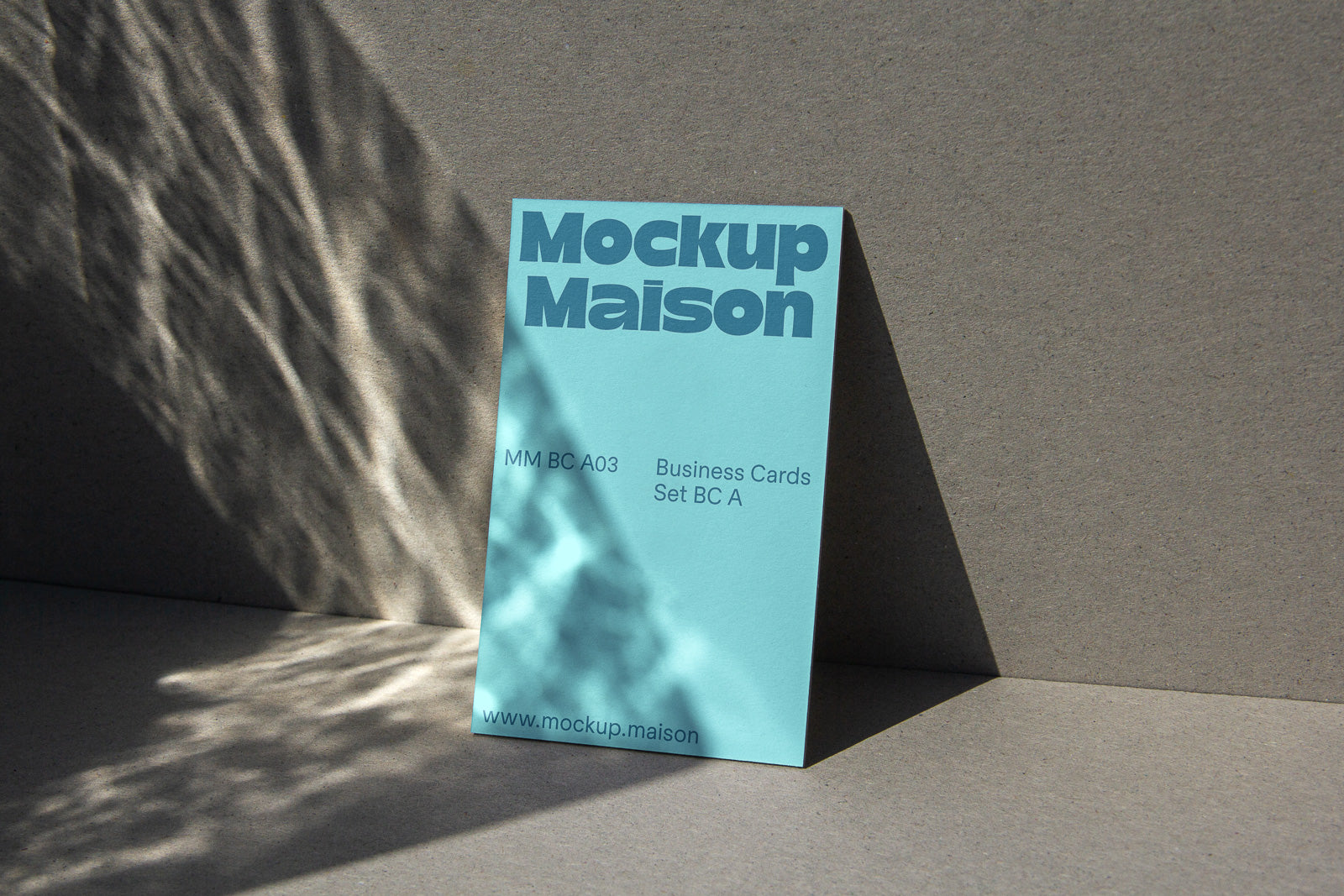 PSD mockup of a vertical business card with the text "Mockup Maison" on a textured background, illuminated by natural light and shadows.