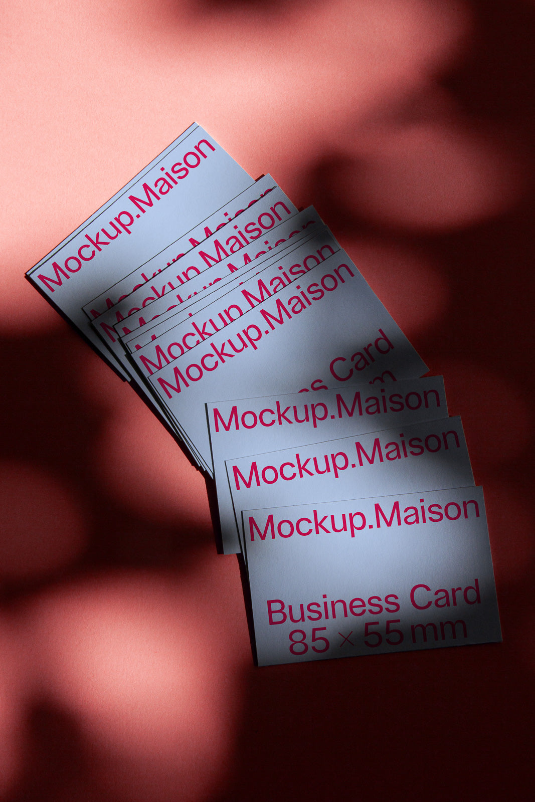 PSD mockup of business cards stacked on a red surface, with "Mockup.Maison" text displayed prominently.