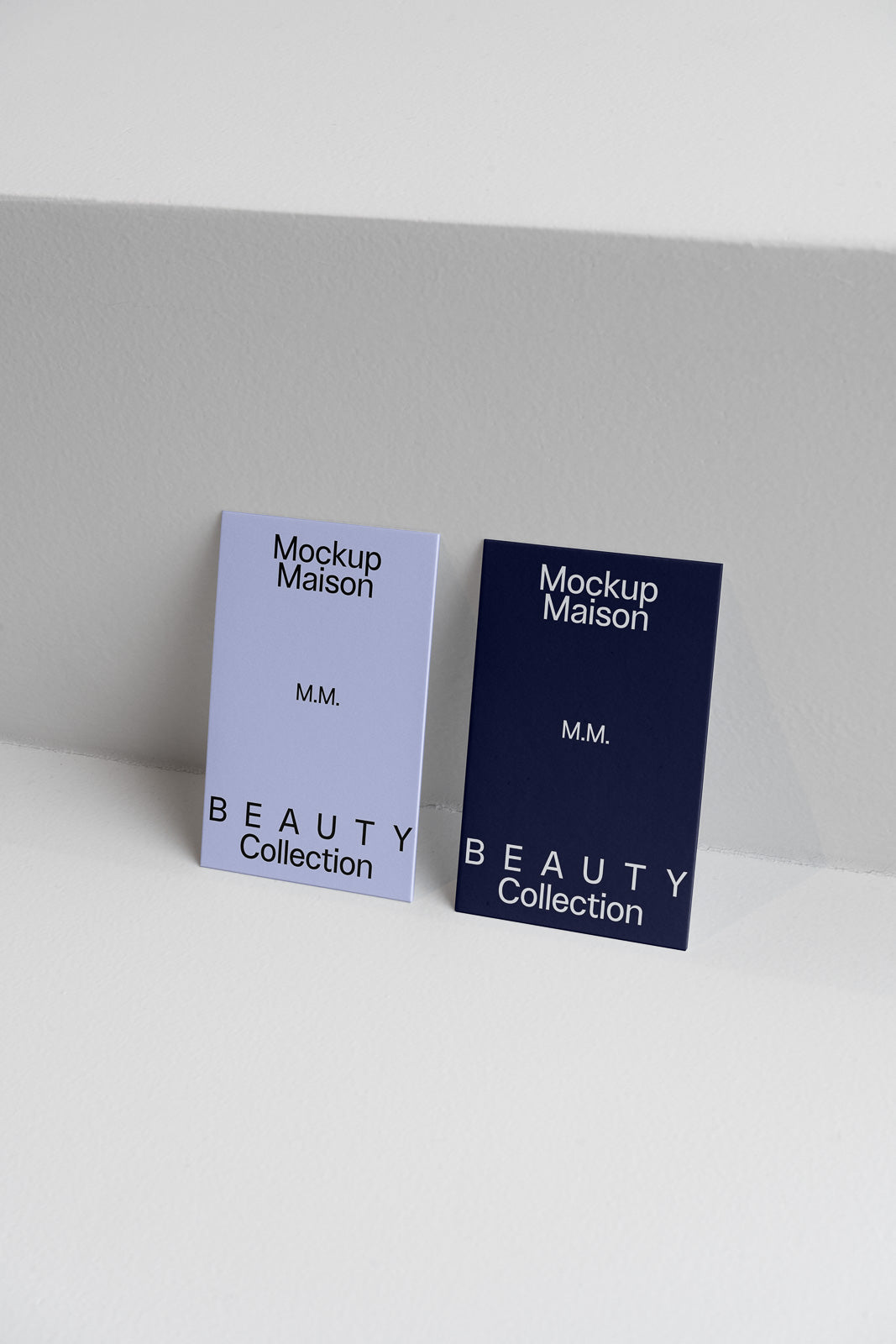 PSD mockup of two rectangular cards leaning against a white surface, featuring "Mockup Maison" and "Beauty Collection". One card is light blue, the other dark blue.