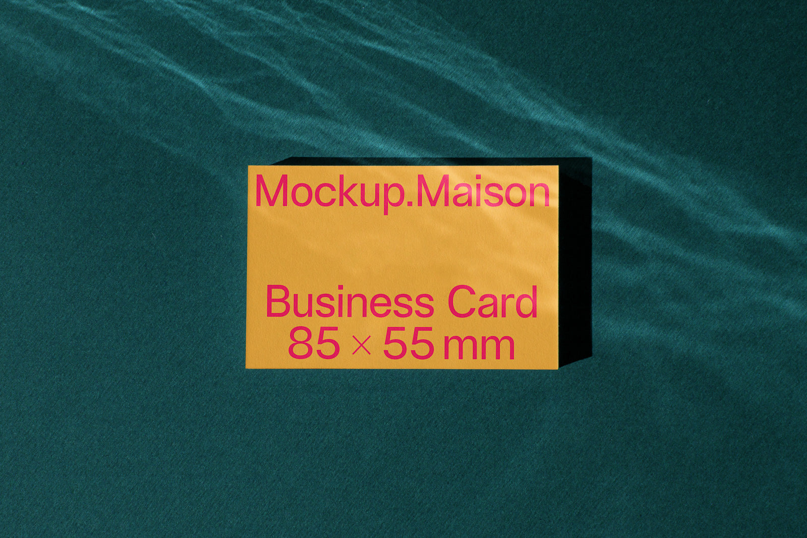PSD mockup of a business card titled "Mockup.Maison" with dimensions 85 × 55 mm, displayed on a textured dark green surface.