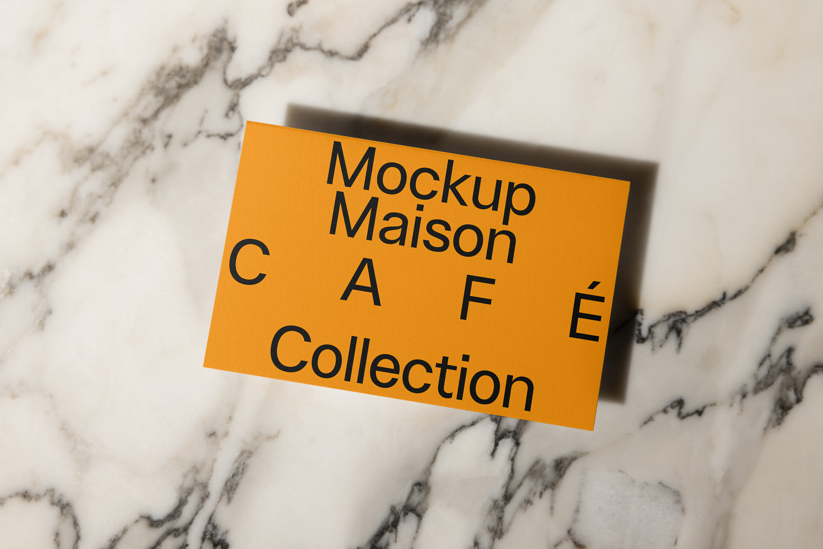 PSD mockup of a card labeled "Mockup Maison CAFE Collection" placed on a marble surface, showcasing elegant typography and shadow details.