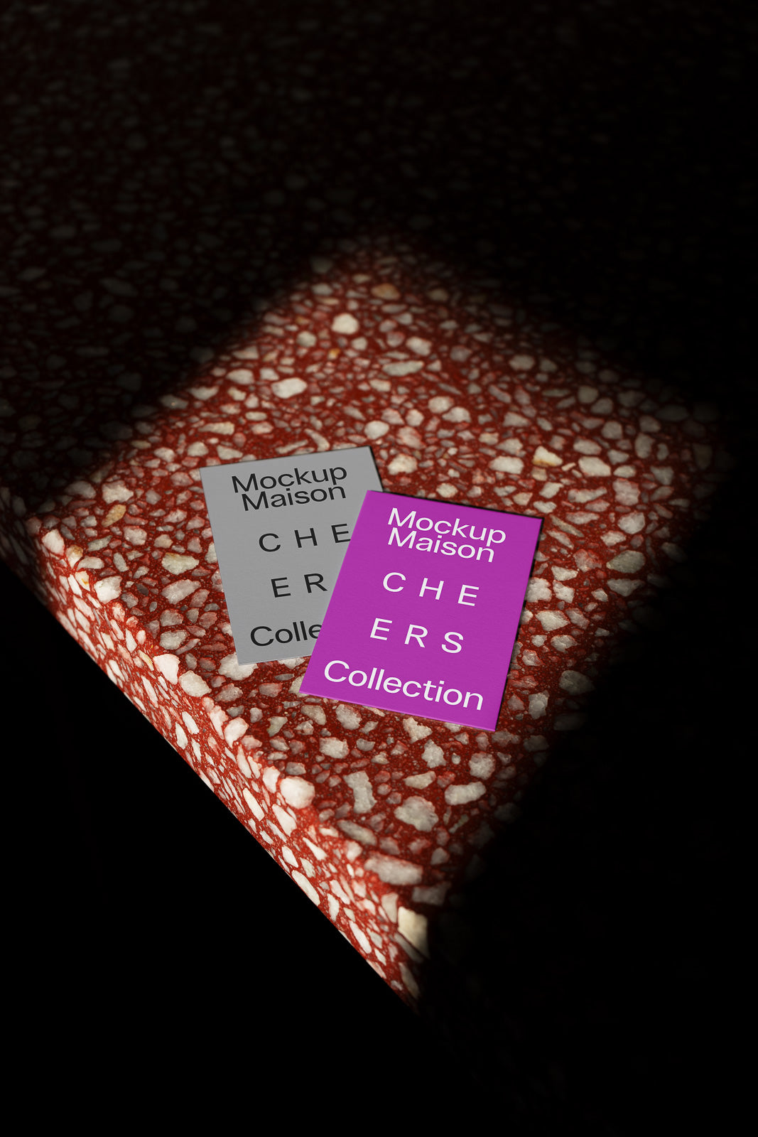 PSD mockup of two "Mockup Maison" cards labeled "CHEERS Collection" on a speckled red and white surface, partially in shadow.
