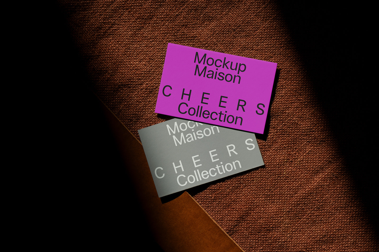 PSD mockup of two cards labeled "CHEERS Collection" on a textured surface, one magenta, one gray, both with "Mockup Maison" text.