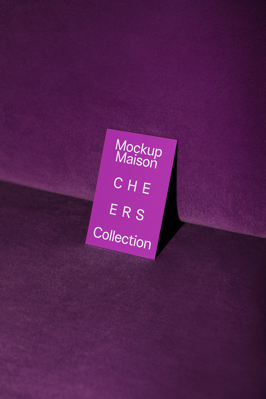 PSD mockup of a purple card with the text "Mockup Maison CHEERS Collection" placed on a matching purple fabric surface.