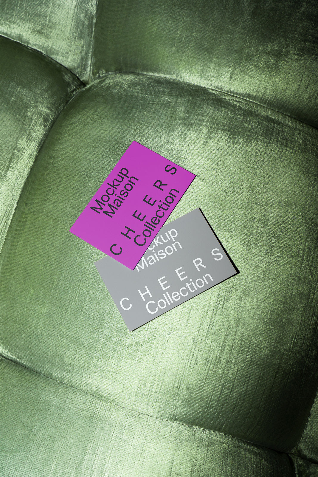 PSD mockup of two cards, one magenta and one gray, on a textured green cushioned surface displaying "Mockup Maison CHEERS Collection."