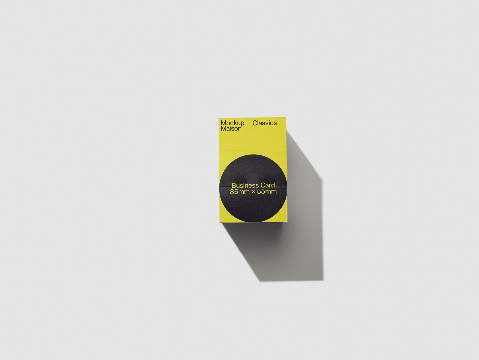 PSD mockup of a stack of business cards in a yellow box with black circle design, showcasing dimensions of 85mm by 55mm against a light background.