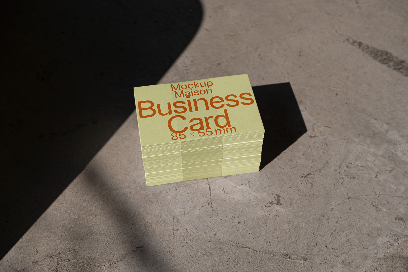 PSD mockup of a stack of olive green business cards on a concrete surface, with "Business Card" written in bold orange text, size 85x55 mm.