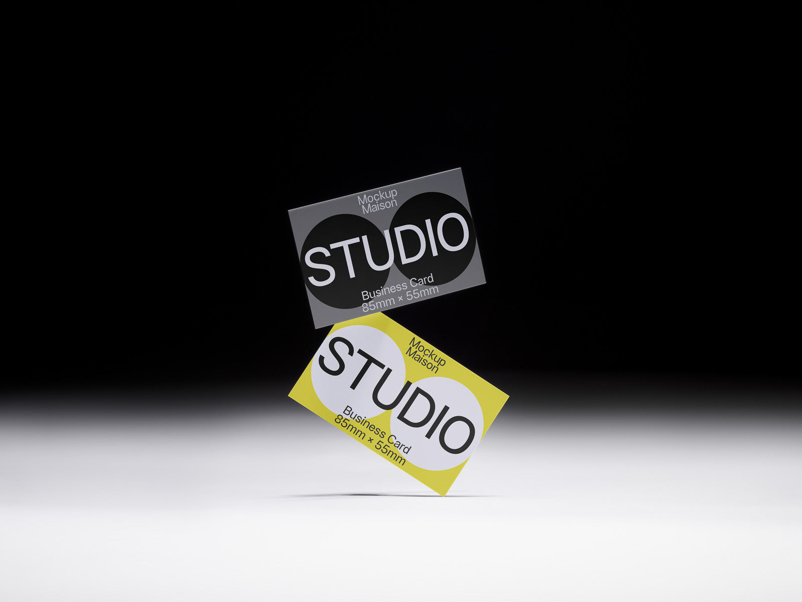 PSD mockup of two floating business cards with "STUDIO" text, one gray and one yellow, on a dark gradient background.