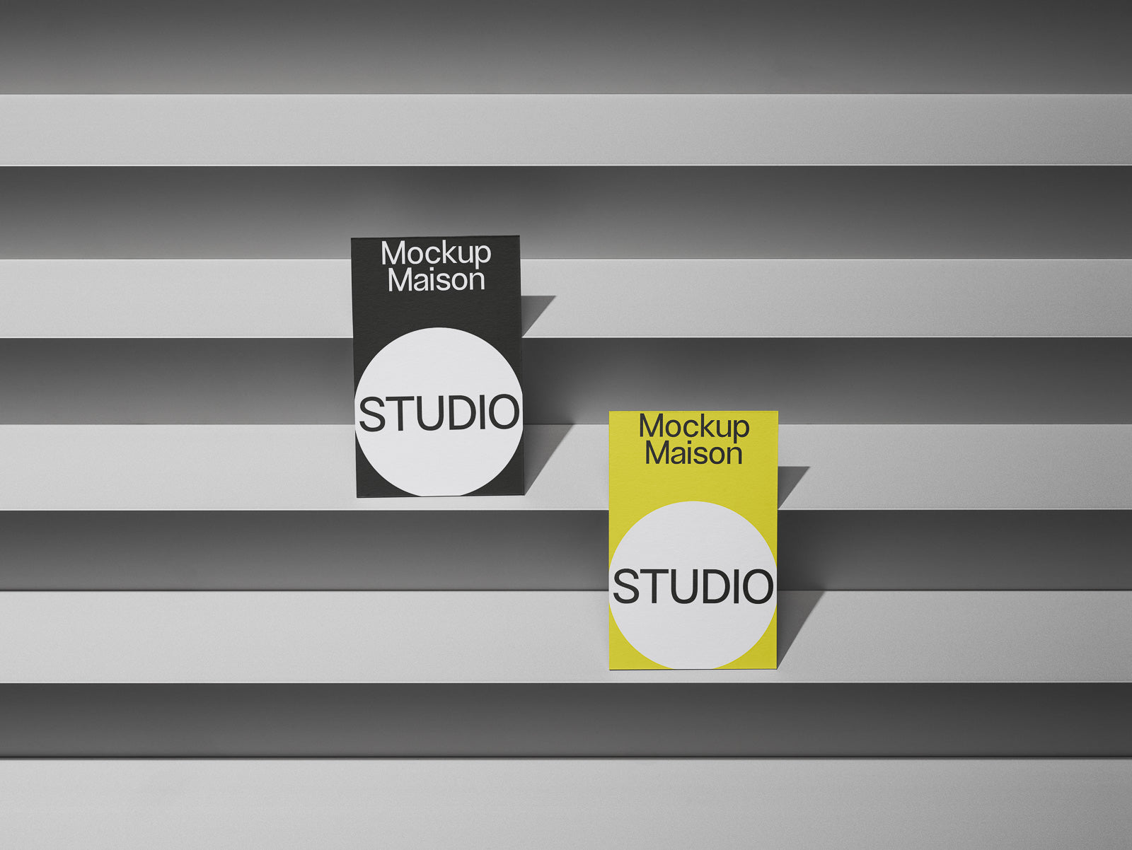 PSD mockup of two vertical studio posters on overlapping horizontal panels, one black and one yellow, both featuring "Mockup Maison" text.