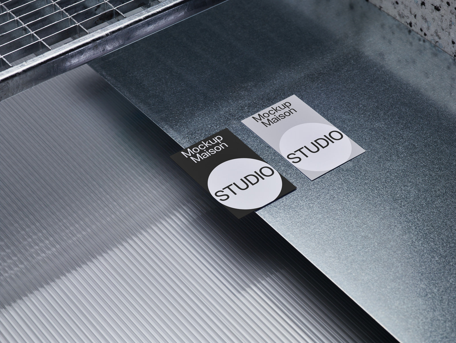 PSD mockup of two cards labeled "Mockup Maison STUDIO" on a reflective metal surface, highlighting texture and light interplay.