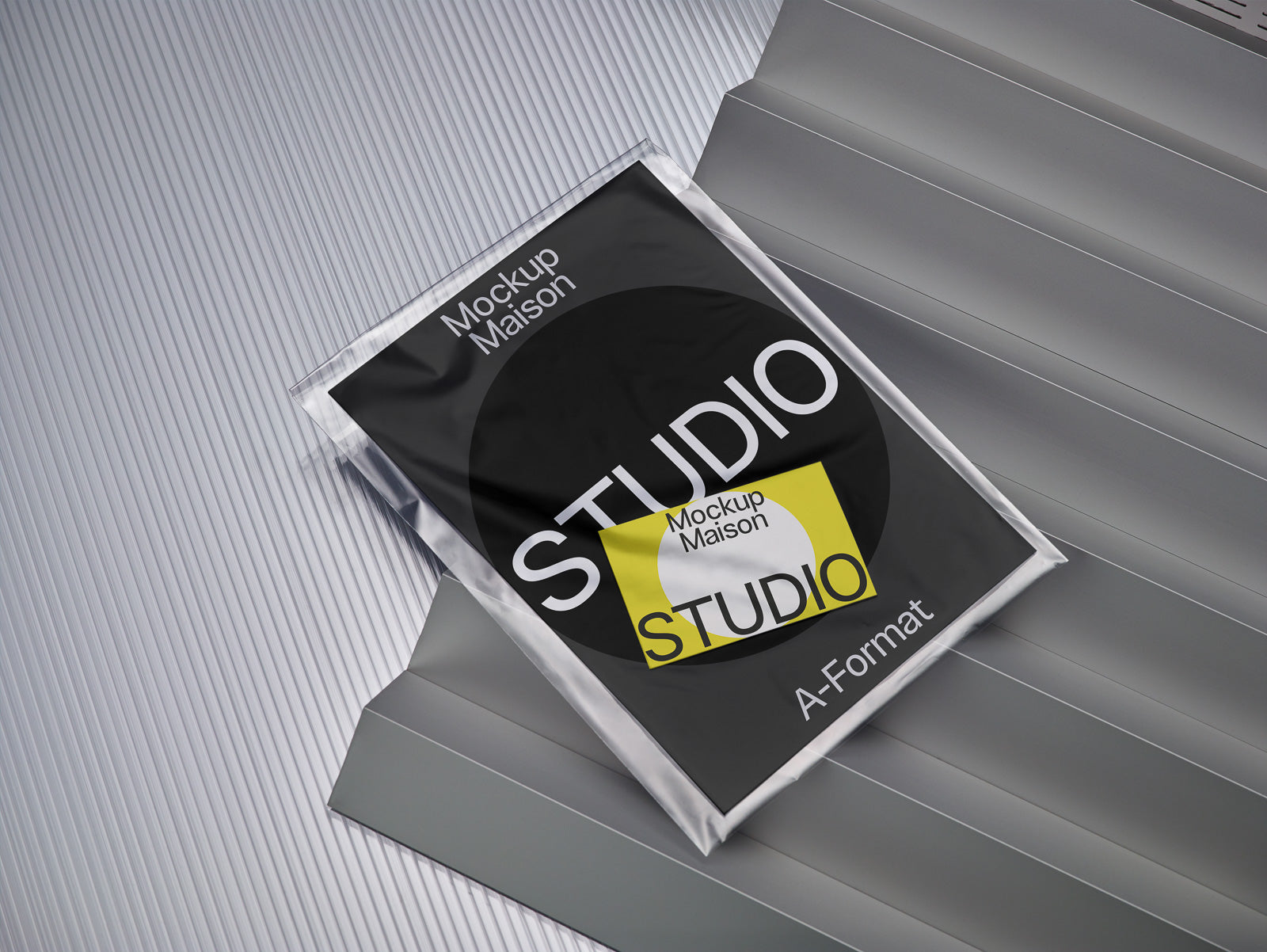 PSD mockup of a studio magazine cover wrapped in plastic, placed on layered gray surfaces with visible text and design elements.