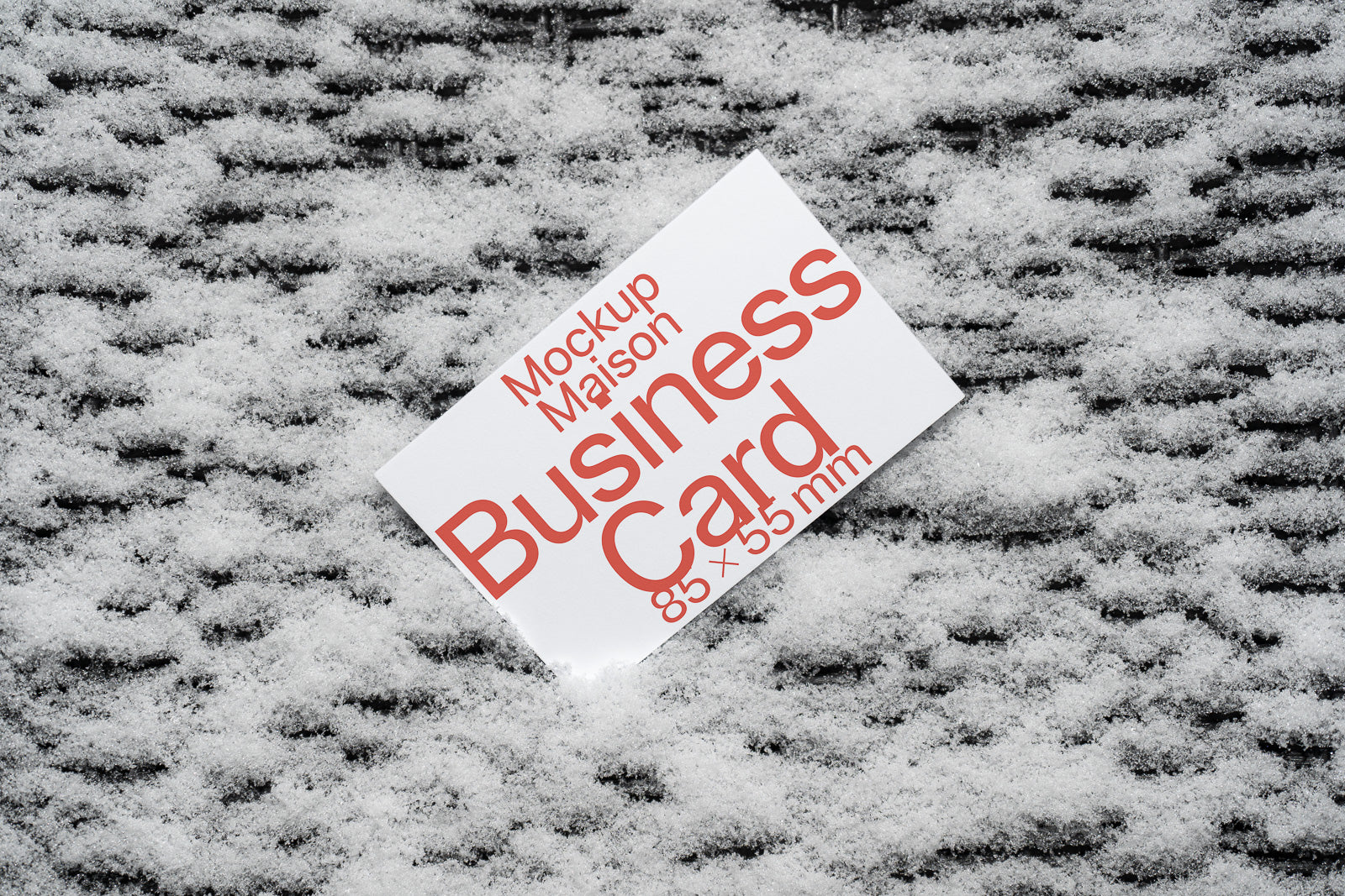 PSD mockup of a business card lying on a textured snowy surface, with red text indicating dimensions of 85 x 55 mm.