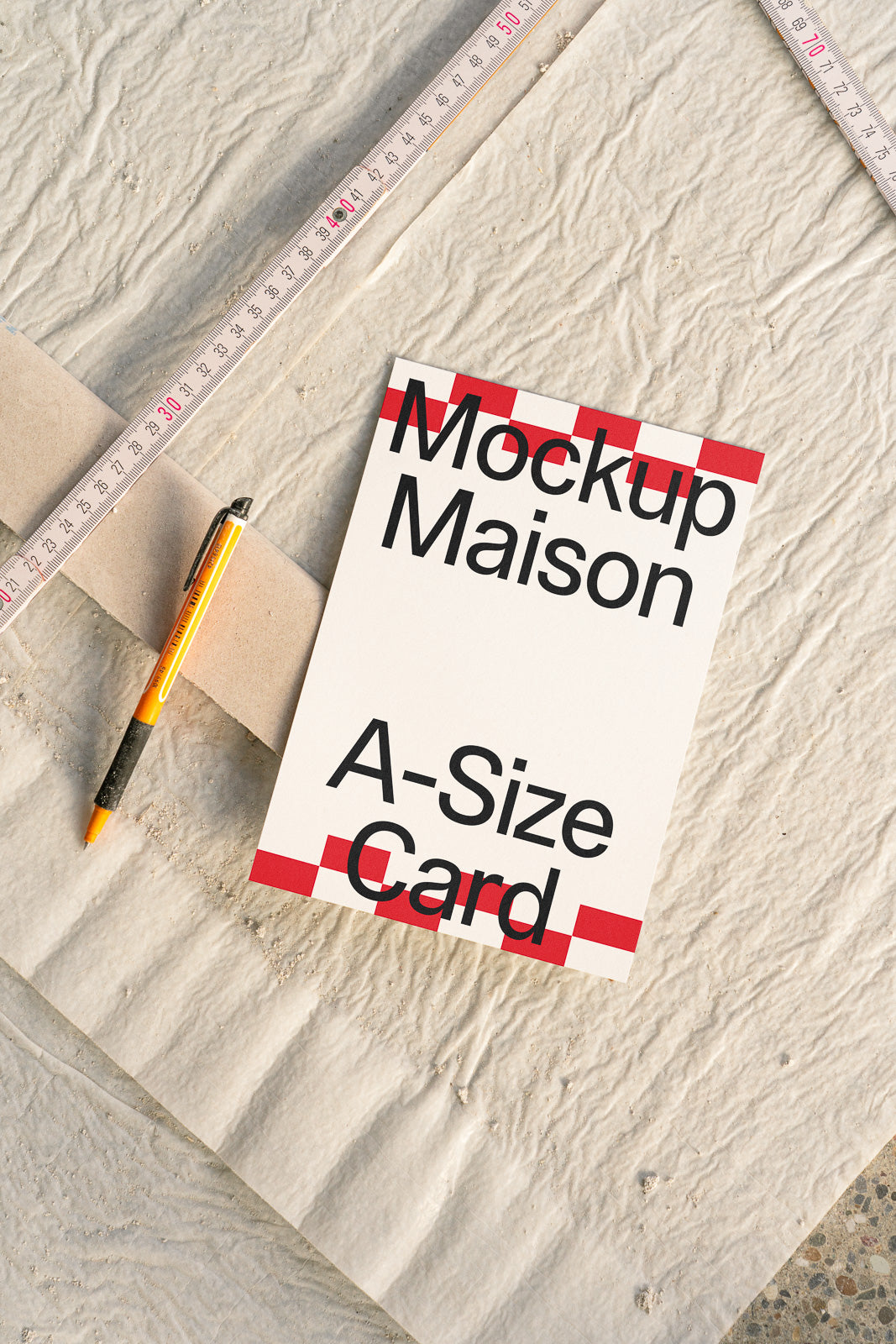 PSD mockup of an A-size card with bold text alongside a ruler and a pen on textured paper. The composition is designed for visual alignment and scale demonstration.