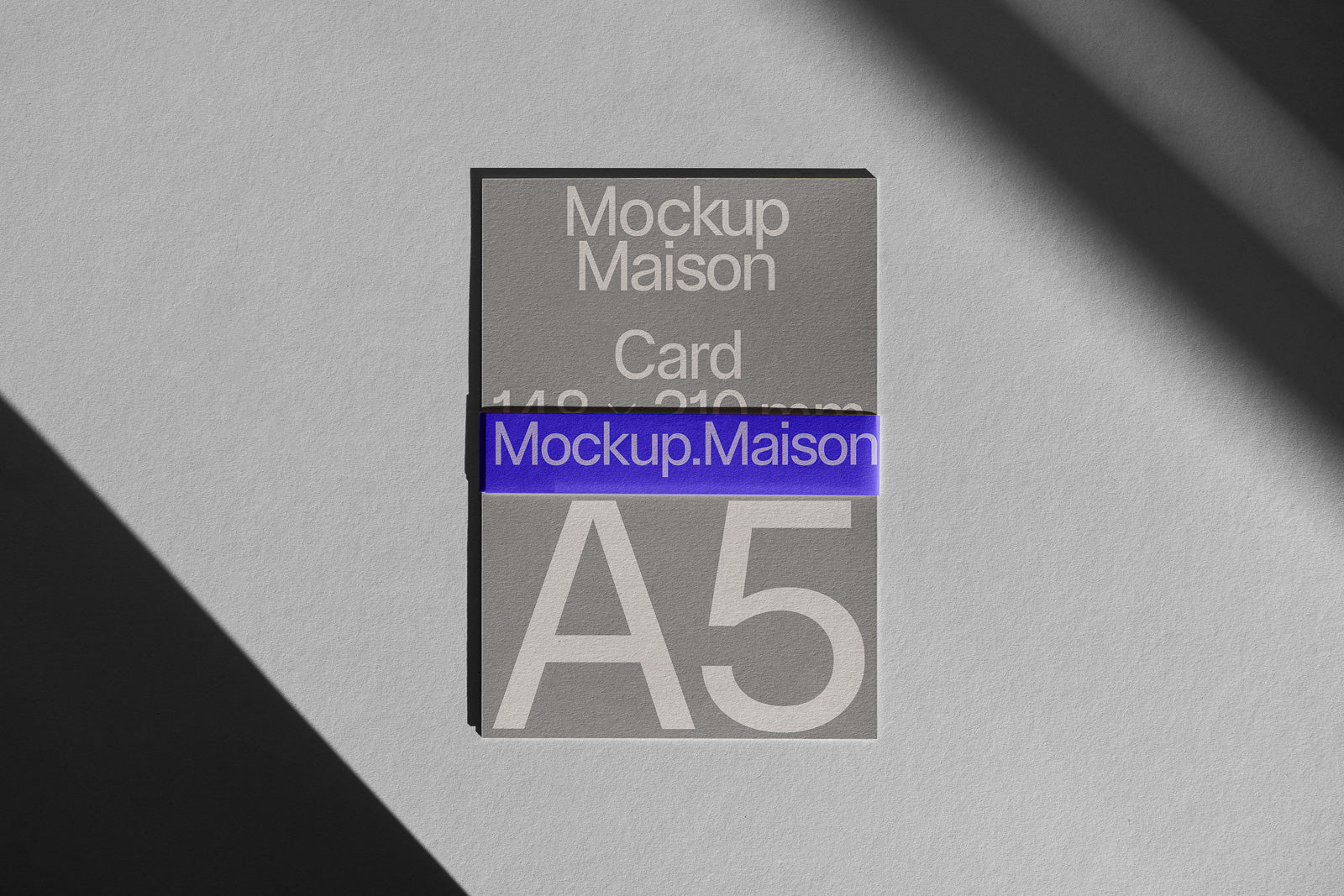 PSD mockup of an A5 card on a textured surface, with "Mockup Maison" text and a blue accent strip running across the center.