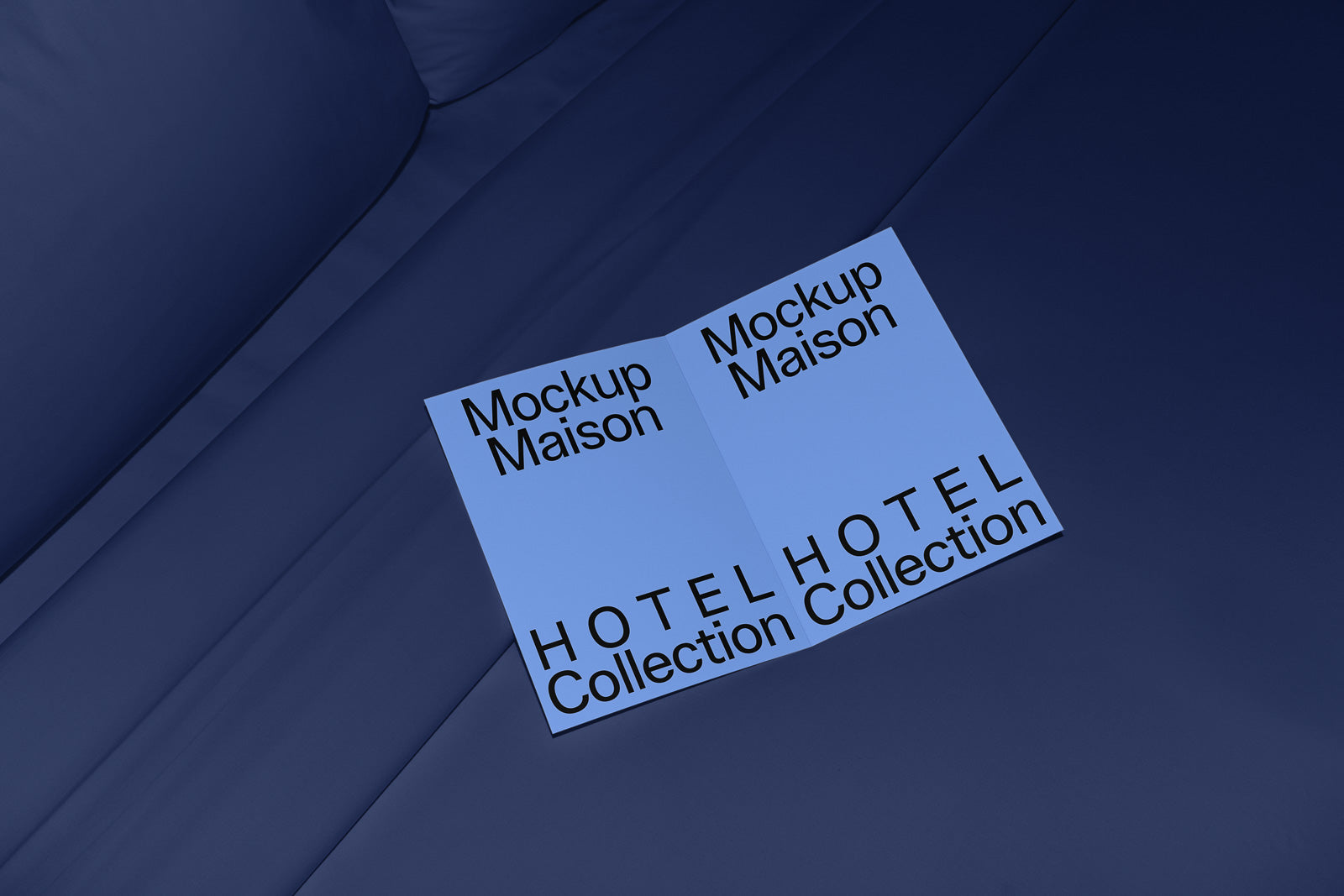 PSD mockup of an open brochure on a dark blue fabric surface with text "Mockup Maison" and "HOTEL Collection Collection" on the pages.