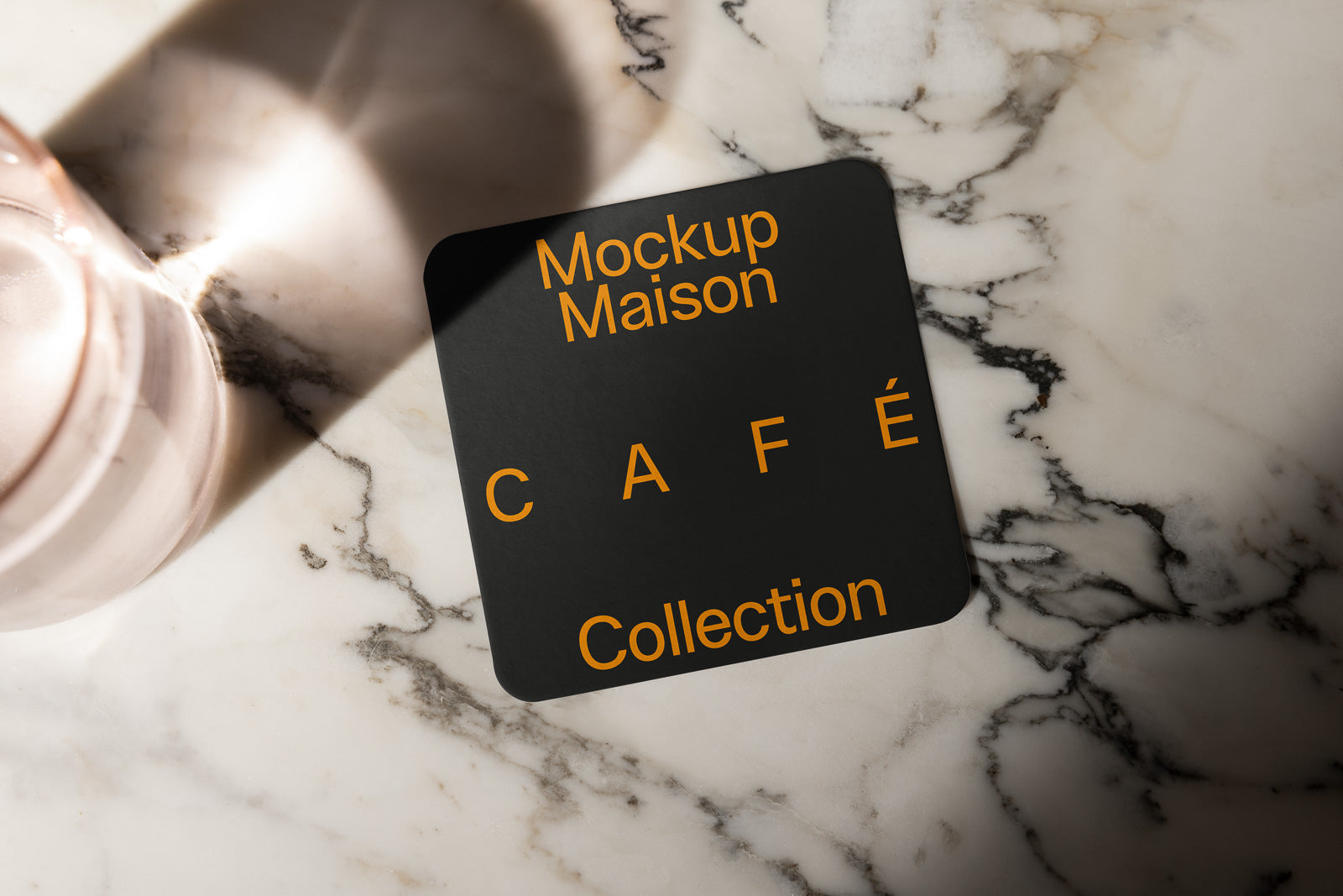 PSD mockup of a square black card with rounded corners on a marble surface, featuring the words "Mockup Maison Café Collection" in orange text.