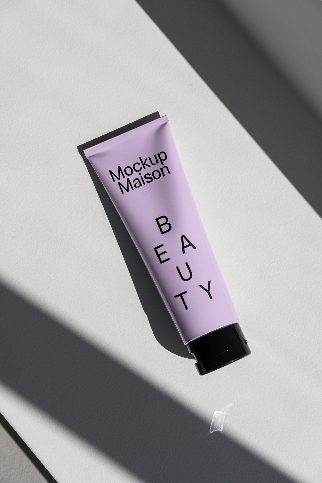 PSD mockup of a lavender tube labeled "Mockup Maison" and "BEAUTY," captured in soft shadow against a textured, neutral background.